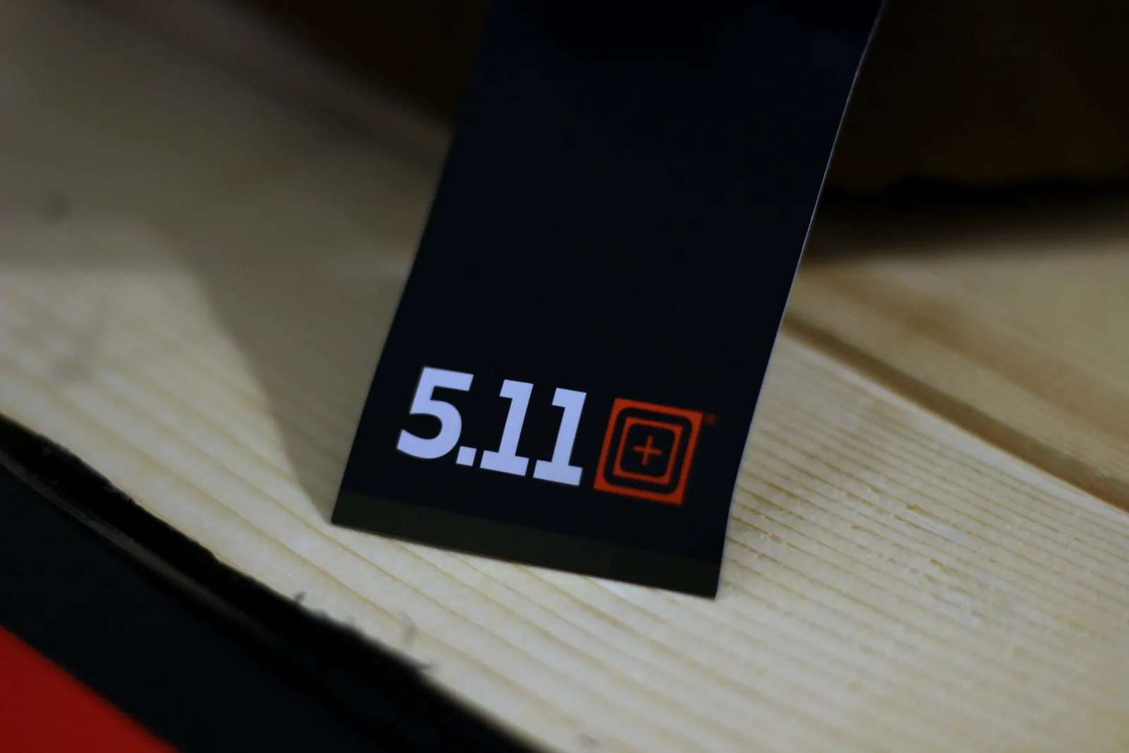 The black 5.11 hang tag lying on a wooden bench