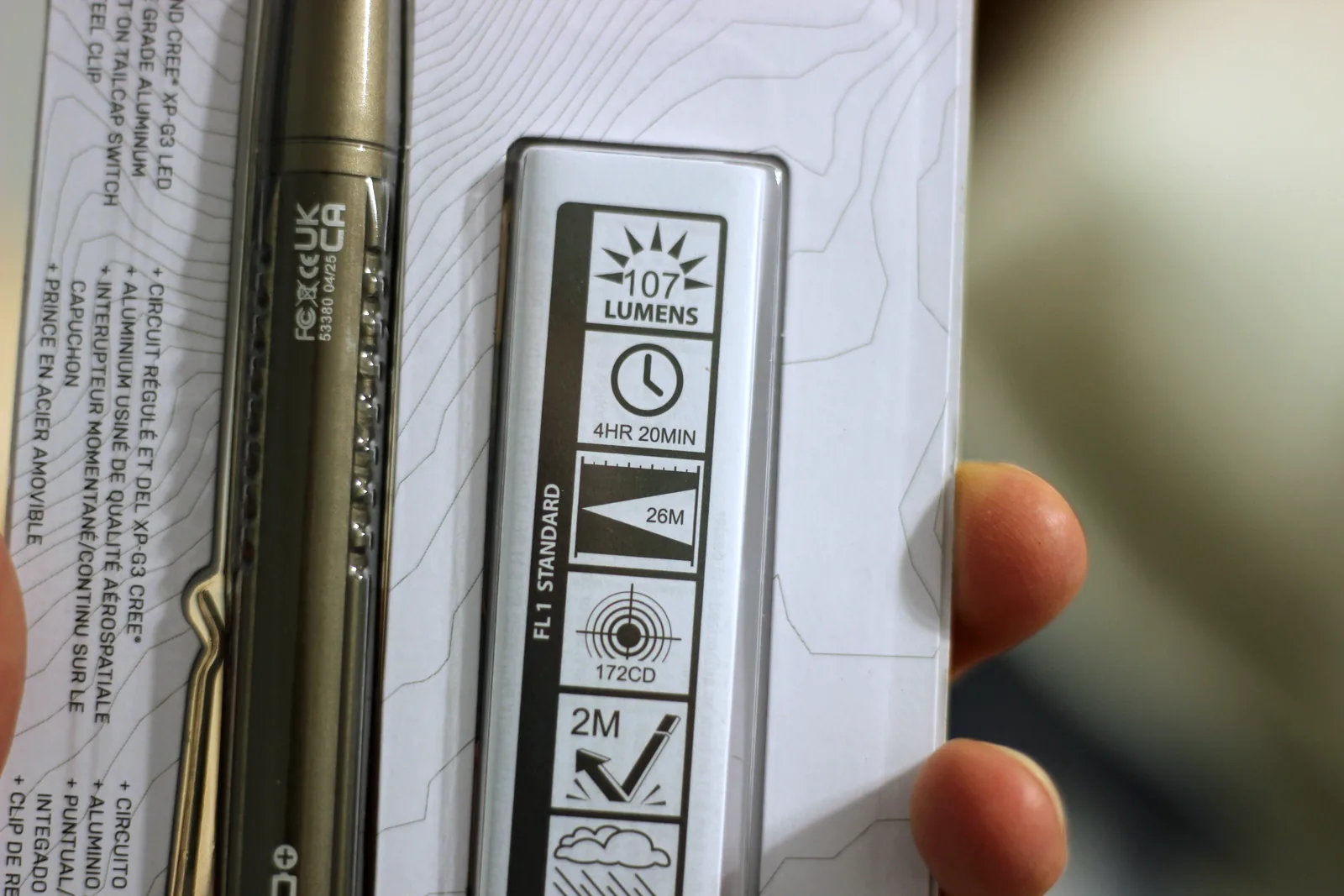 The FL1 standard panel on the flashlight package showing 107 lumens, 4hr 20min, 26m, 172cd and 2m impact