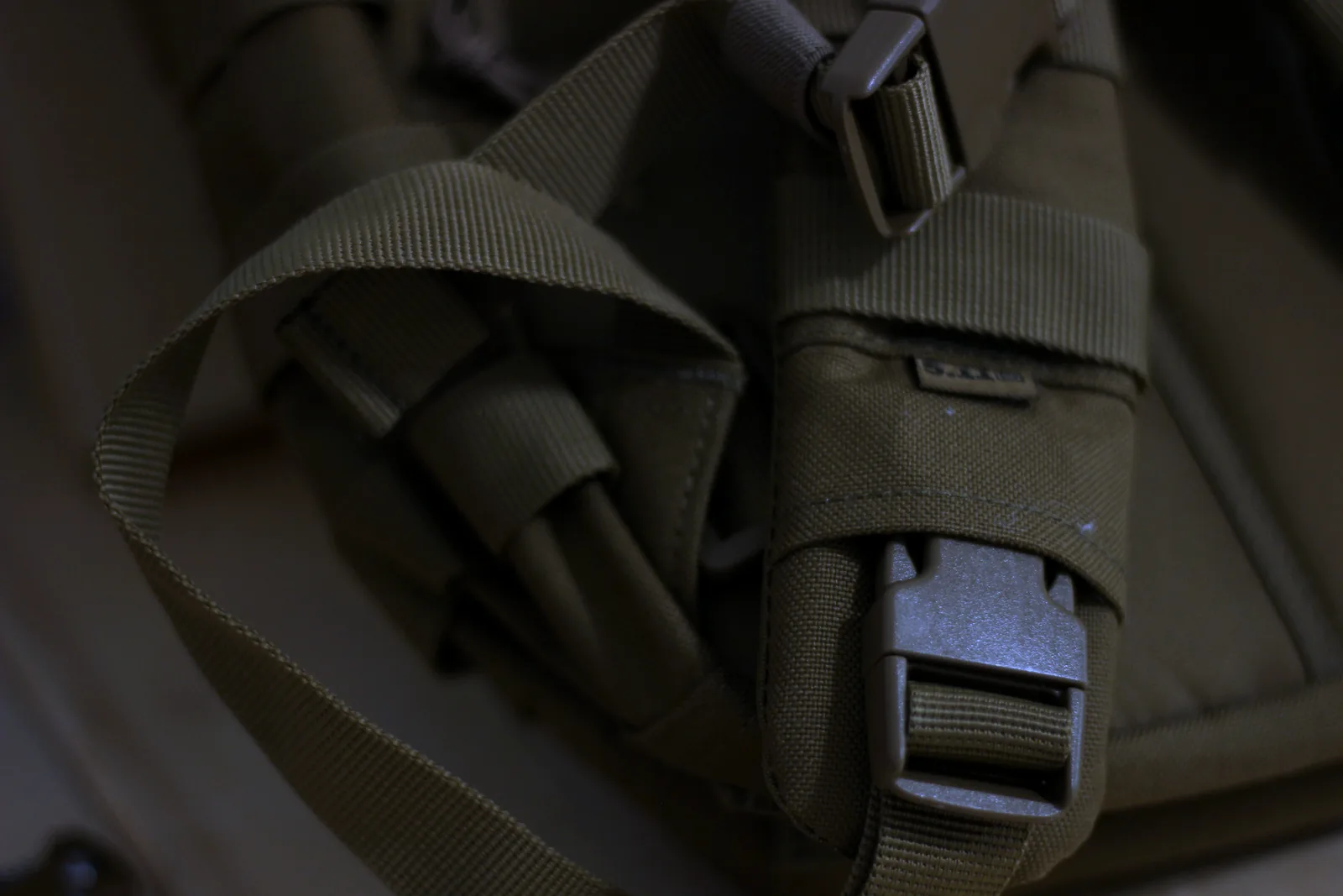 Close-up of the side-release buckles and webbing keepers on the compression straps