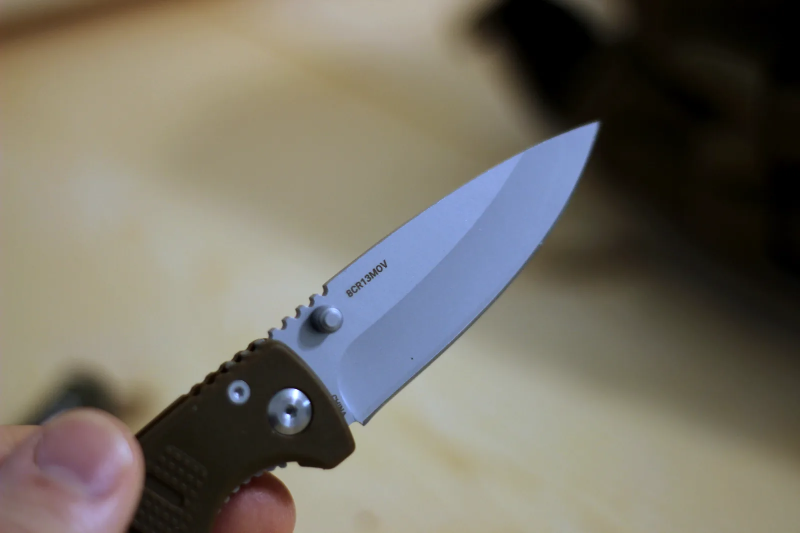 The Icarus DP Mini open in hand with the 8Cr13MoV steel mark visible on the blade