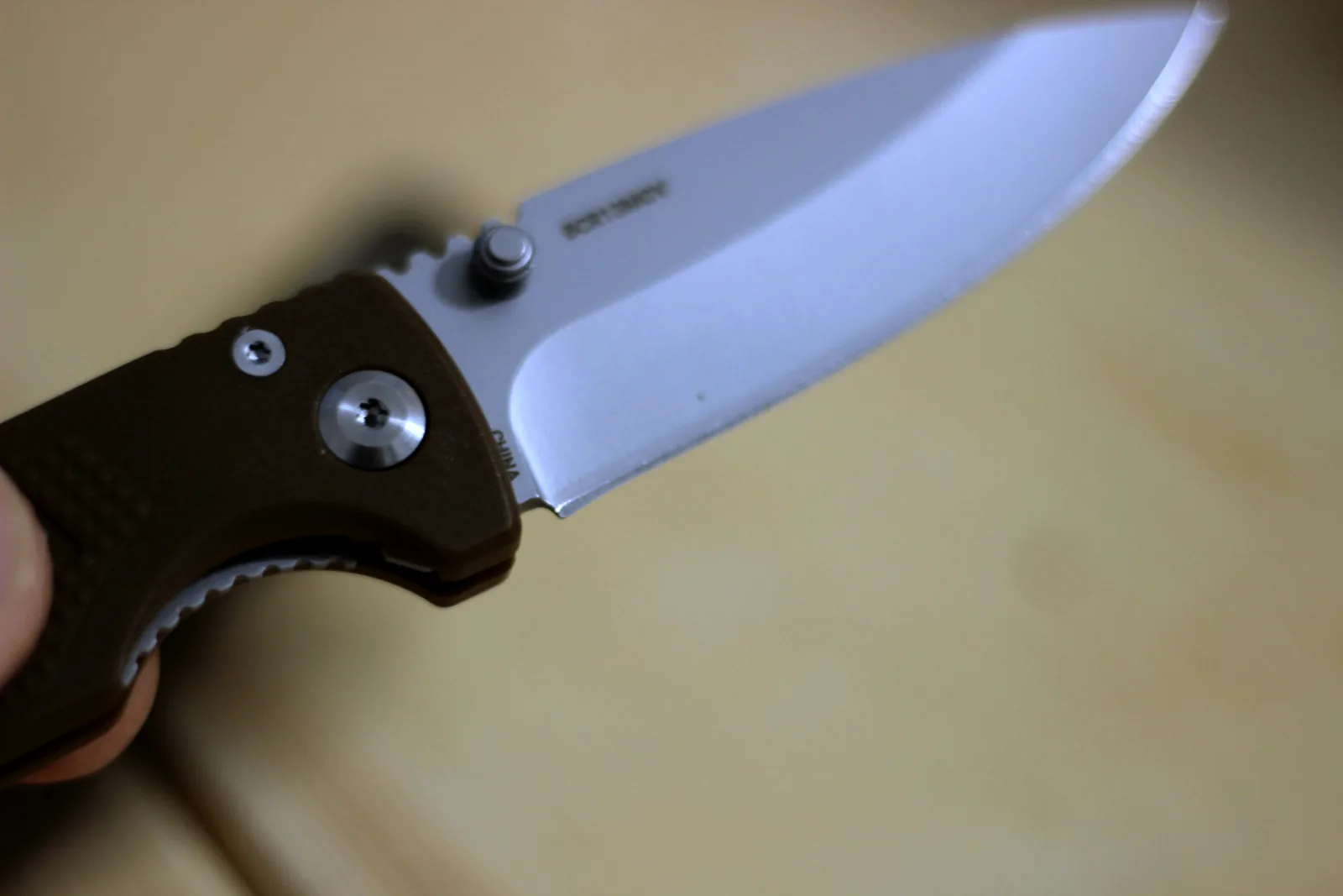 The pivot, thumb stud and spine jimping of the open knife