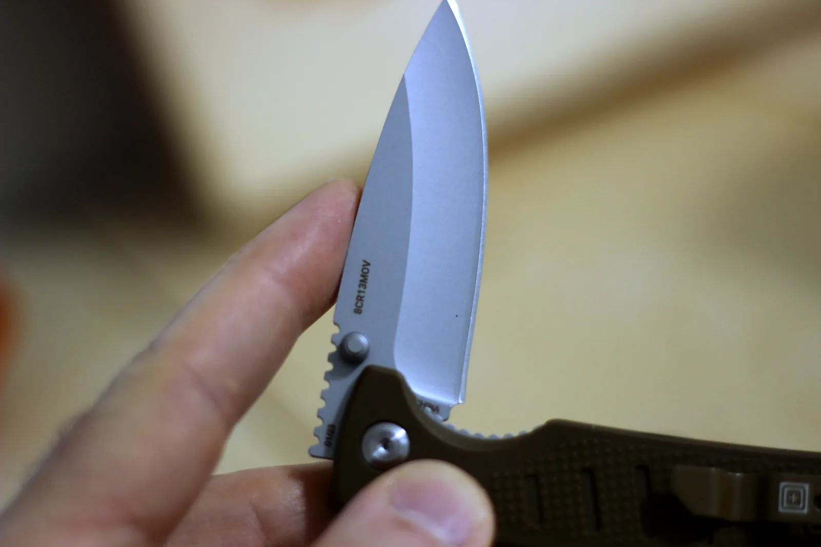 The open knife held above the coyote-coloured pack