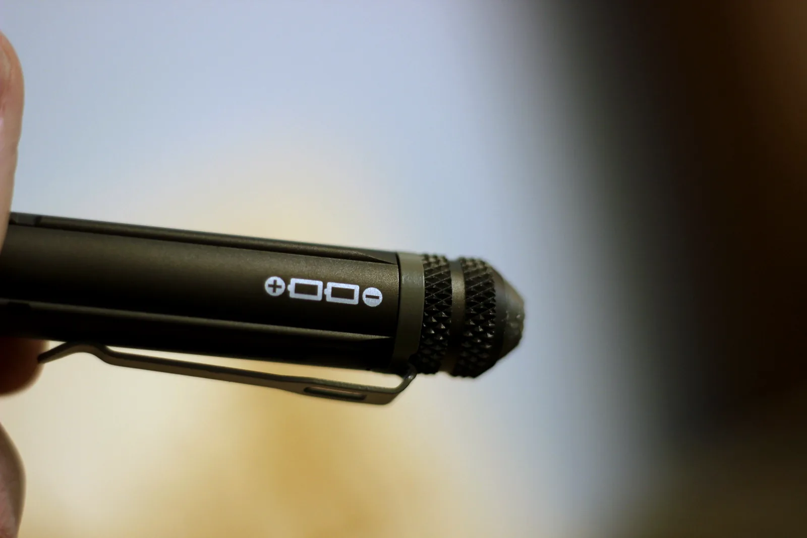 A small diagram etched on the flashlight barrel showing battery orientation