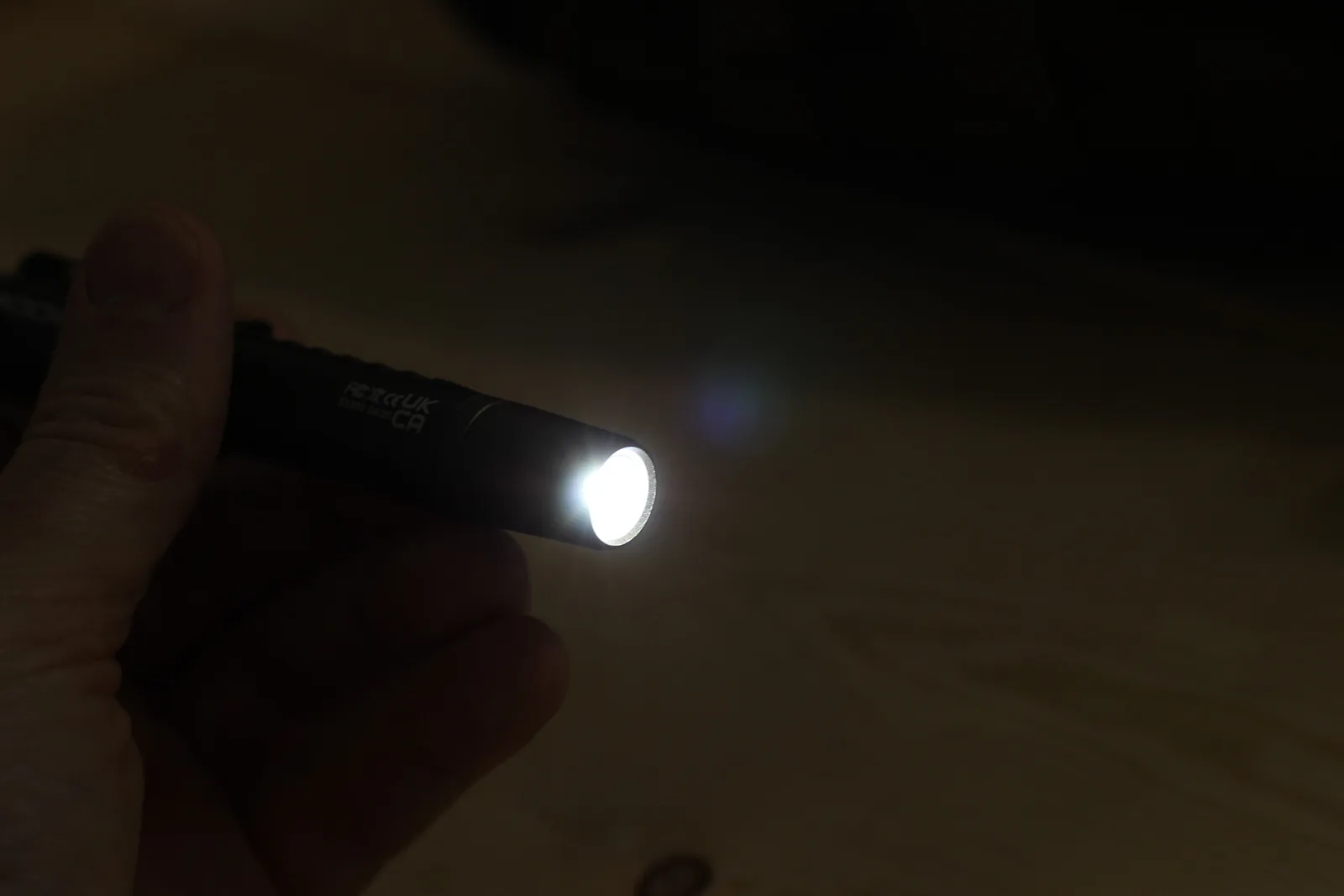 The flashlight throwing a bright white beam in a dark room