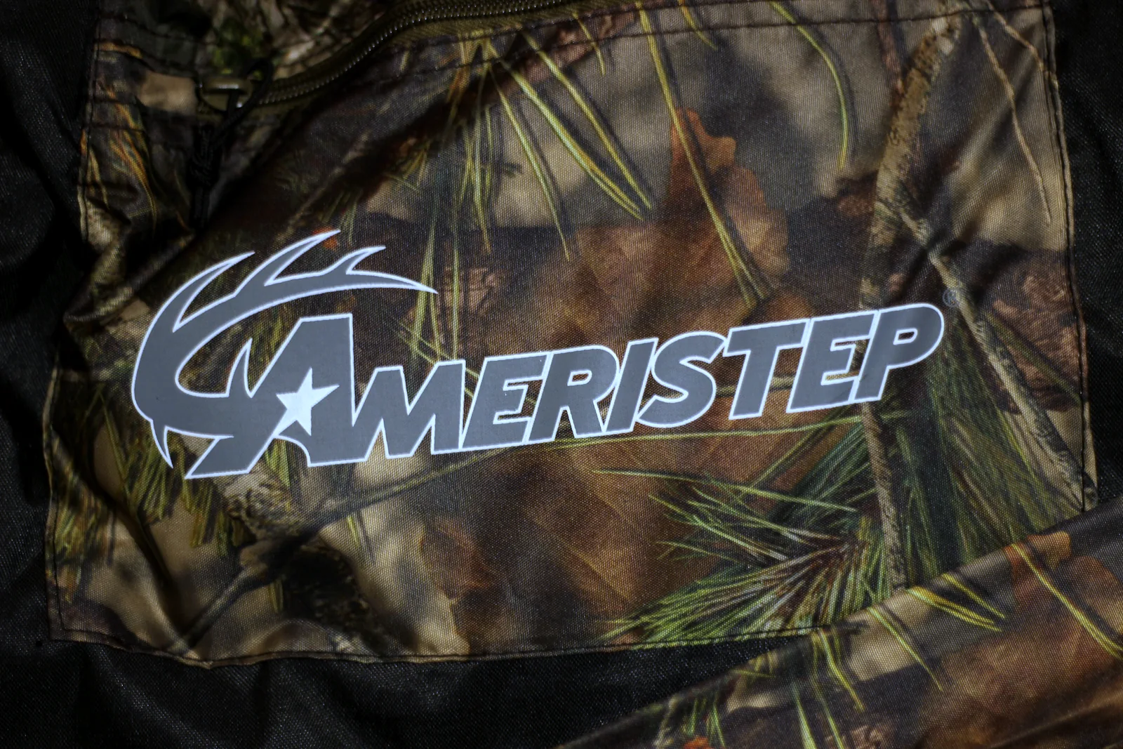 The white Ameristep logo printed on the camo carry case