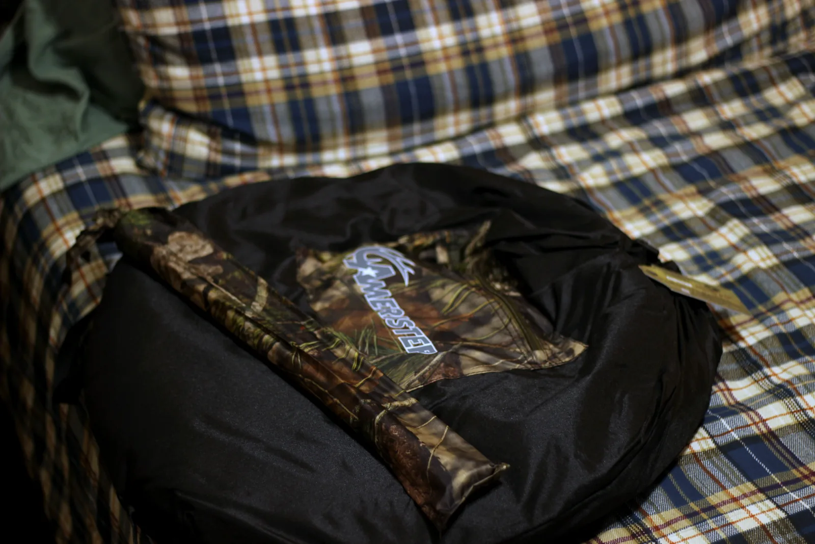 The carry case unzipped with the folded blind and its zipper pull visible
