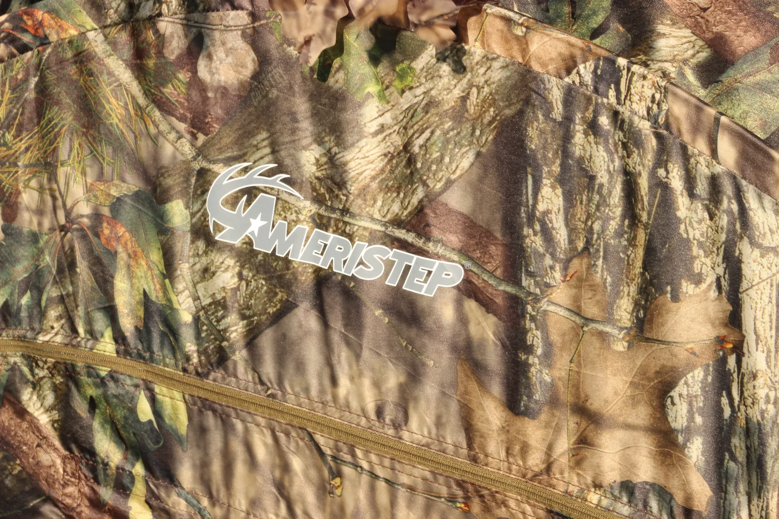 Close-up of the Ameristep logo on the Mossy Oak Break-Up Country shell with the cut-leaf edge trim alongside