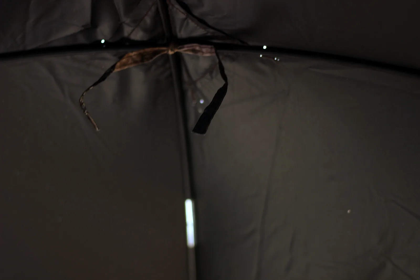 The interior roof of the blind showing the hub, black coated fabric and fabric gear ties
