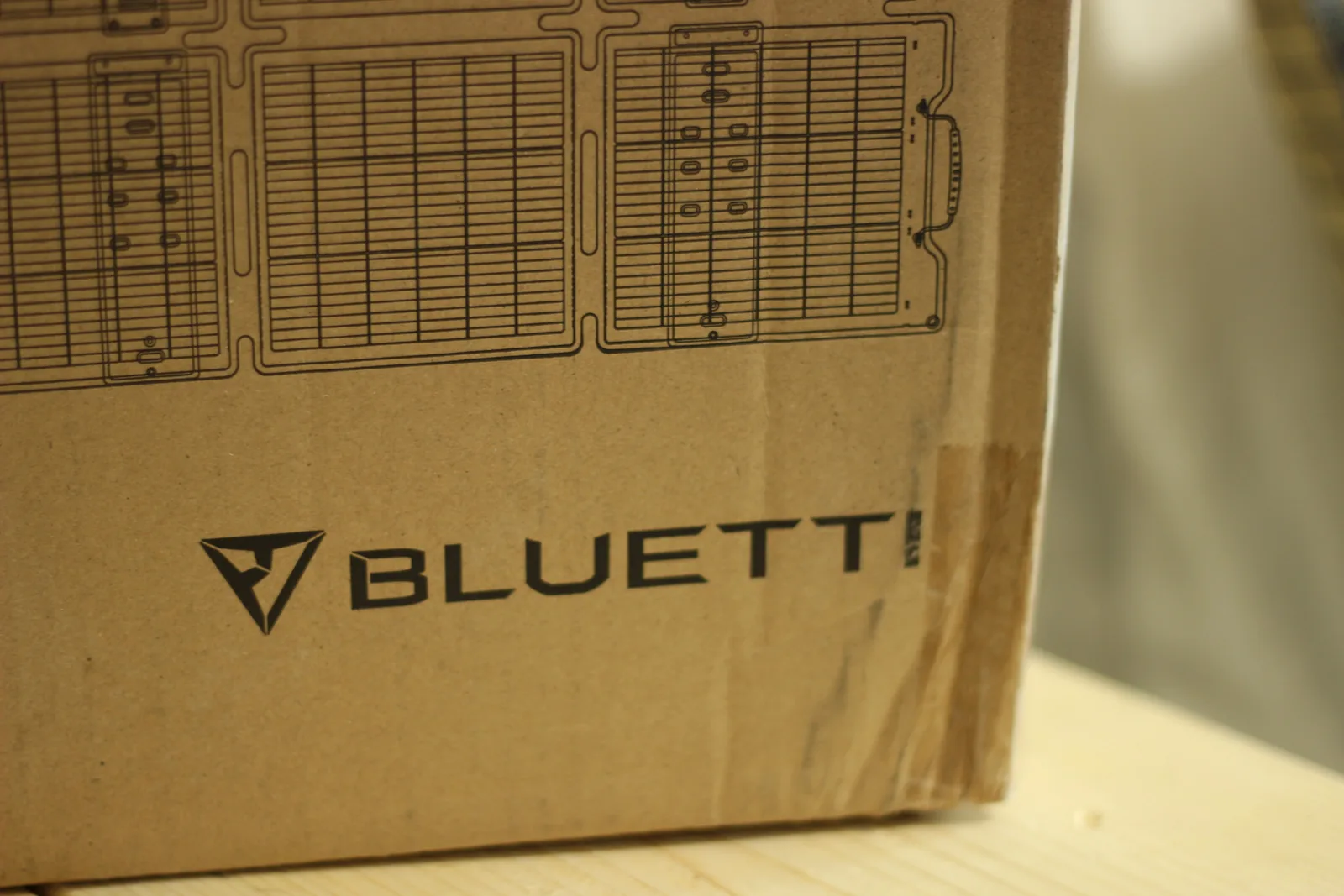 Corner of the carton showing the BLUETTI wordmark below a line illustration of the unfolded panel sections