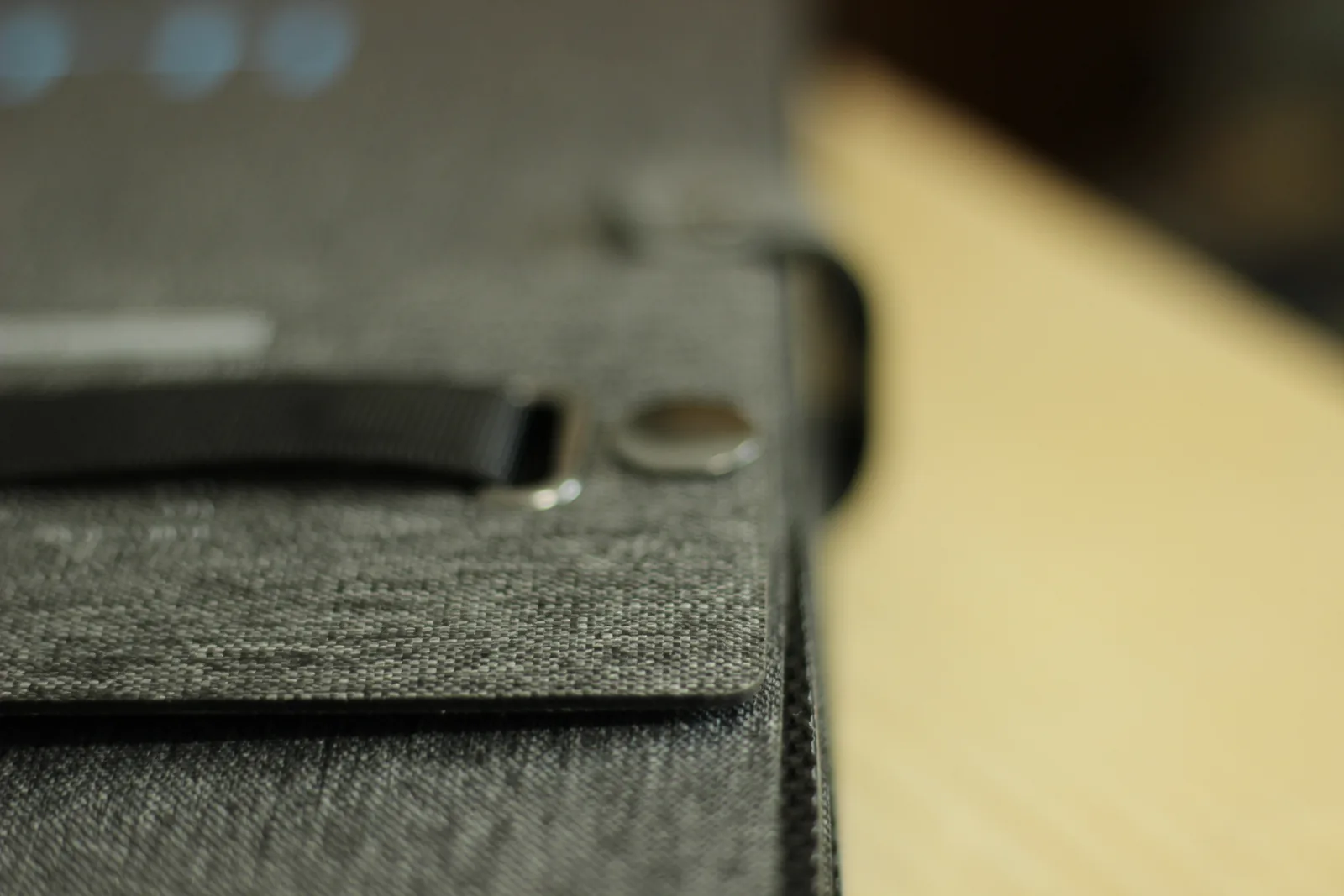Close-up of the webbing strap anchored to the panel case beside a metal eyelet