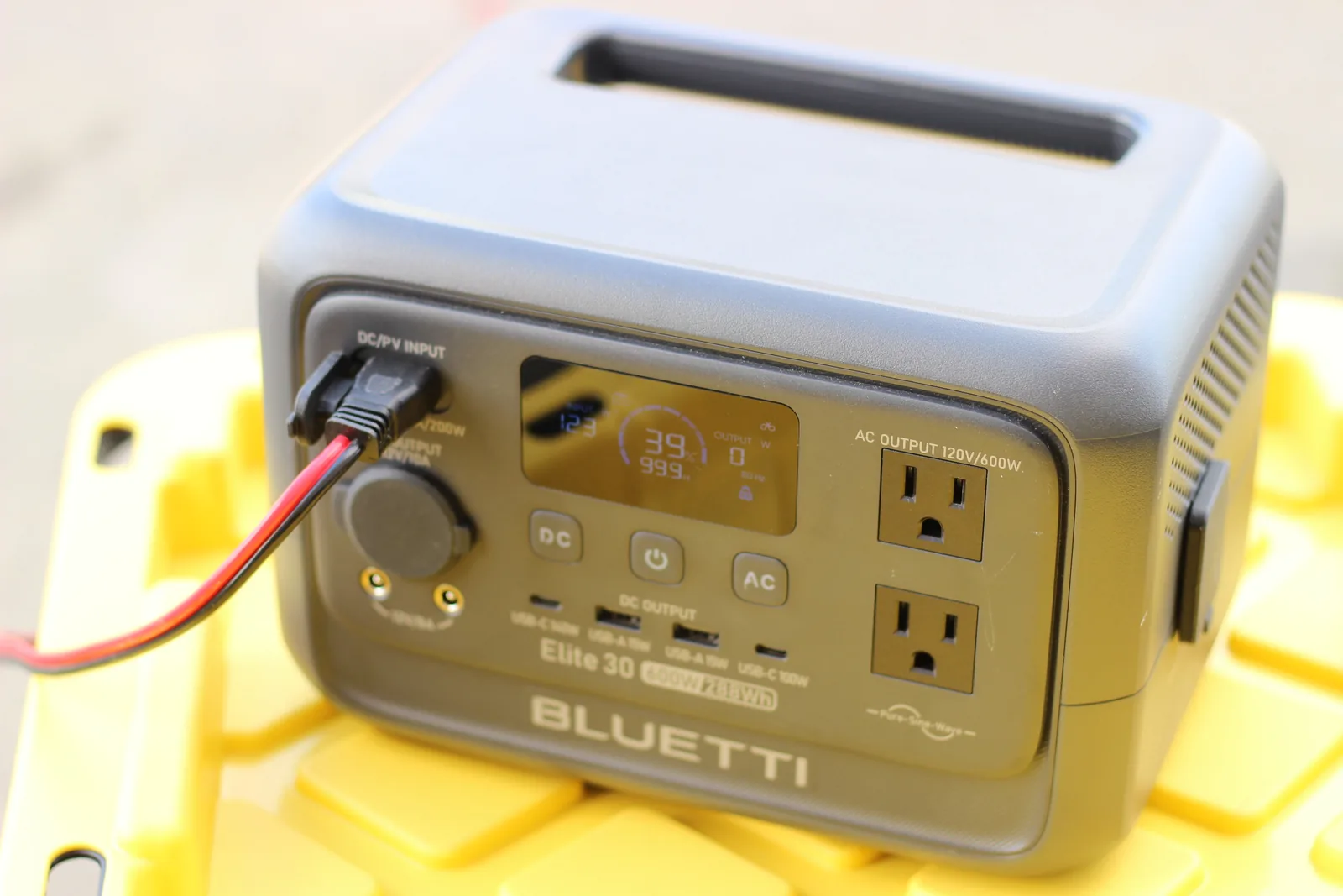 The front of the BLUETTI Elite 30 with the solar lead plugged into the DC/PV input, display showing charge state