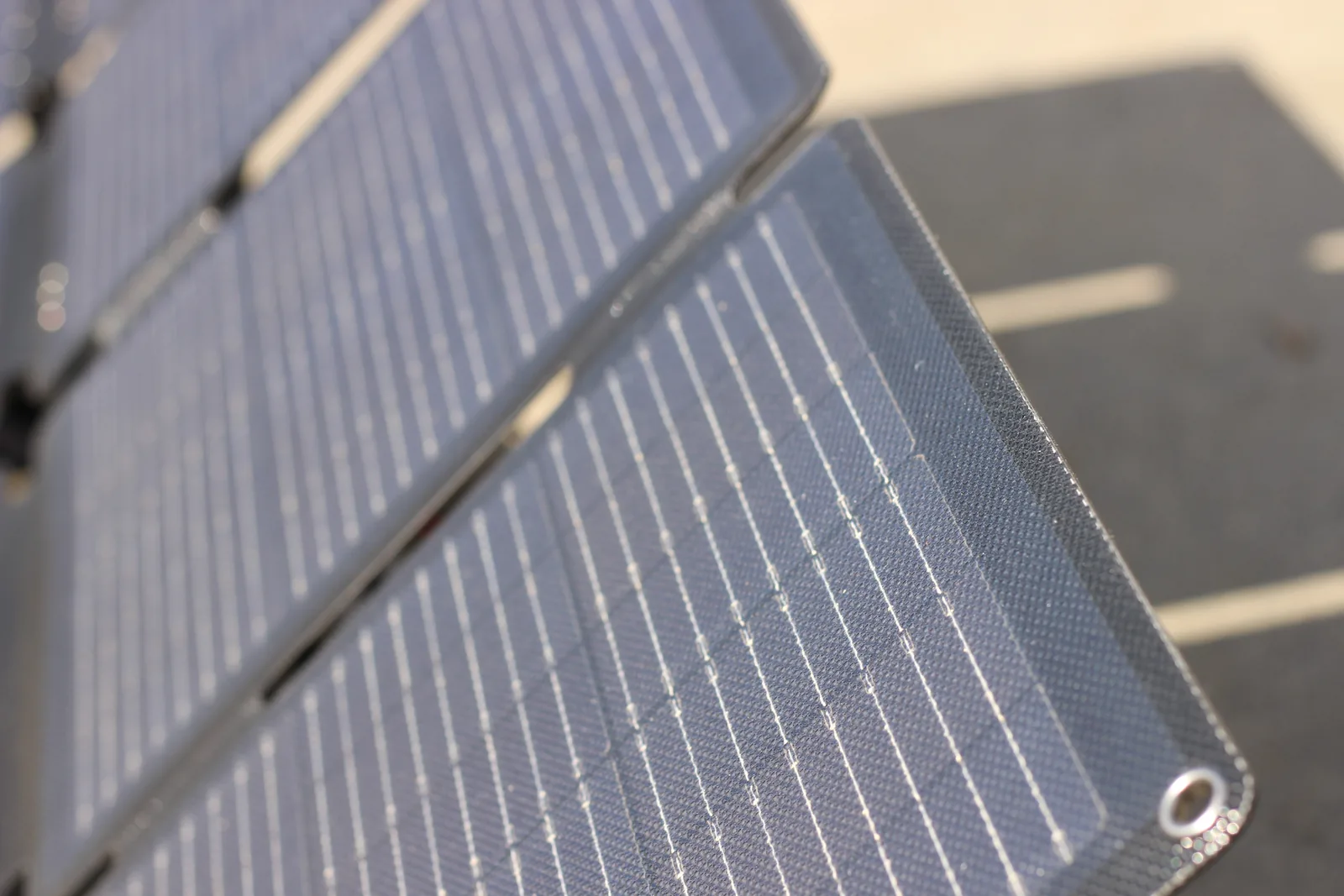Macro of the panel surface showing the fine textured ETFE lamination over the silver busbar lines of the monocrystalline cells