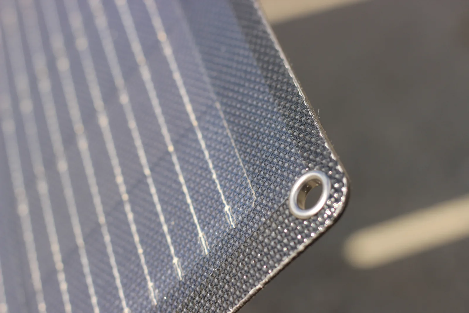 A metal eyelet set into the laminated corner of the panel with the fabric edge binding visible