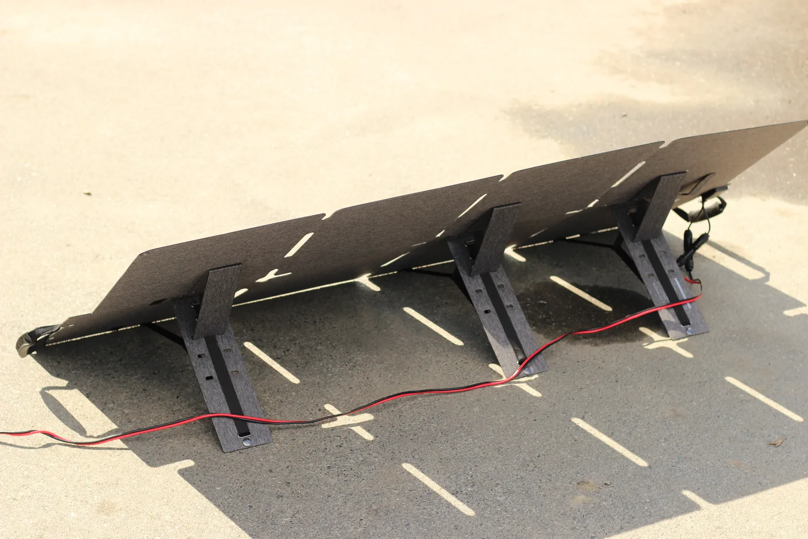 The back of the deployed panel on a driveway showing three kickstand panels propping it at an angle