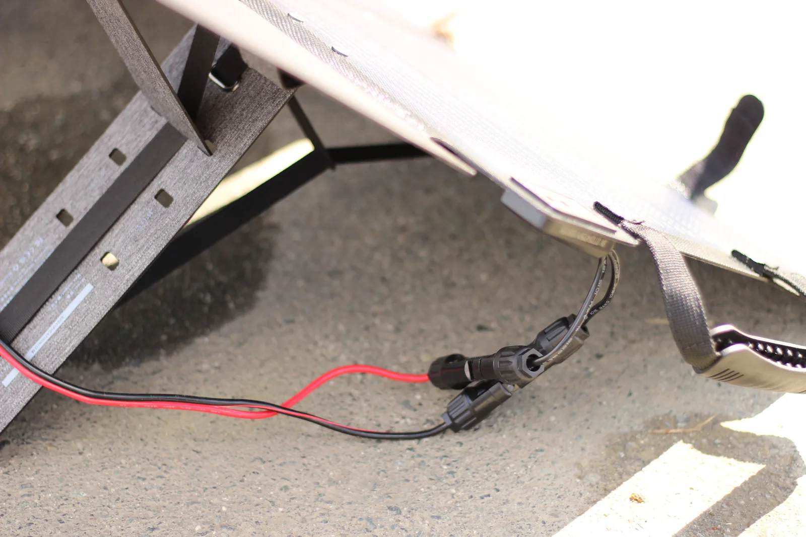 The MC4 connectors joined together underneath the deployed panel on the driveway