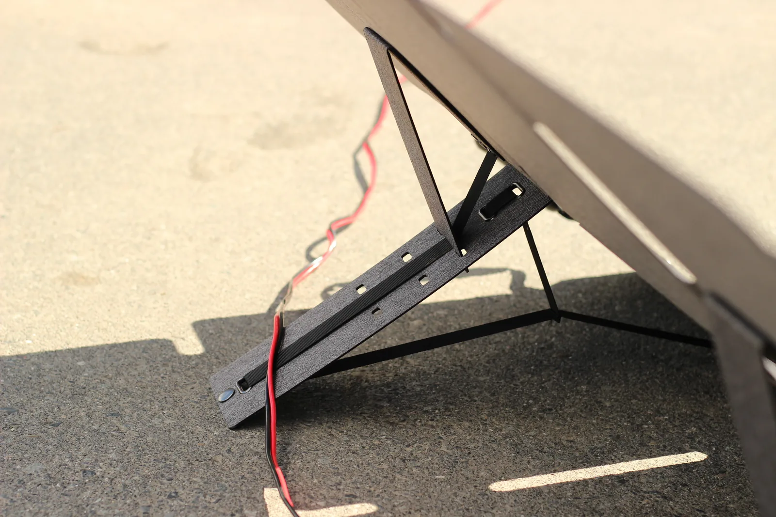 The panel set at a steeper angle on its kickstand, casting a shadow on the driveway