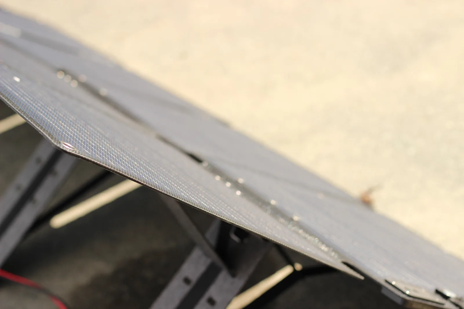 The panel photographed edge-on in profile showing how thin the laminated section is