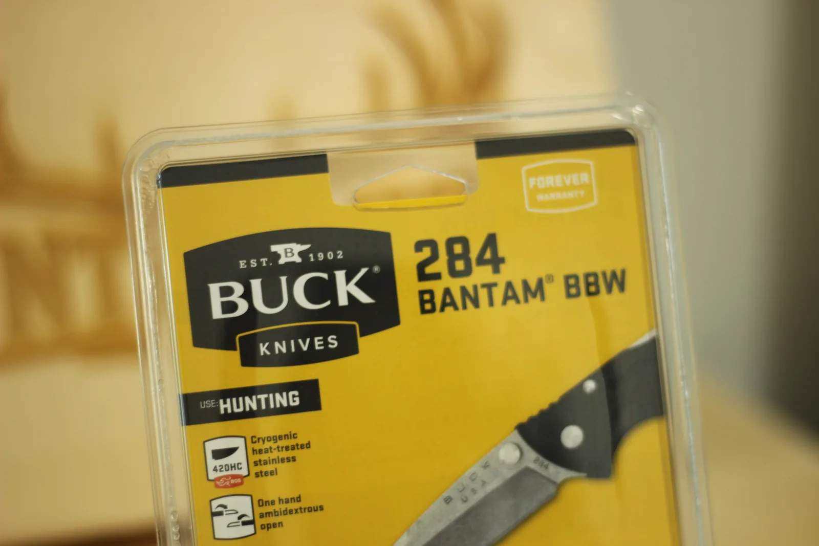Front of the yellow Buck blister card reading 284 Bantam BBW with the Buck Knives anvil logo, a Forever Warranty badge and a USE HUNTING label
