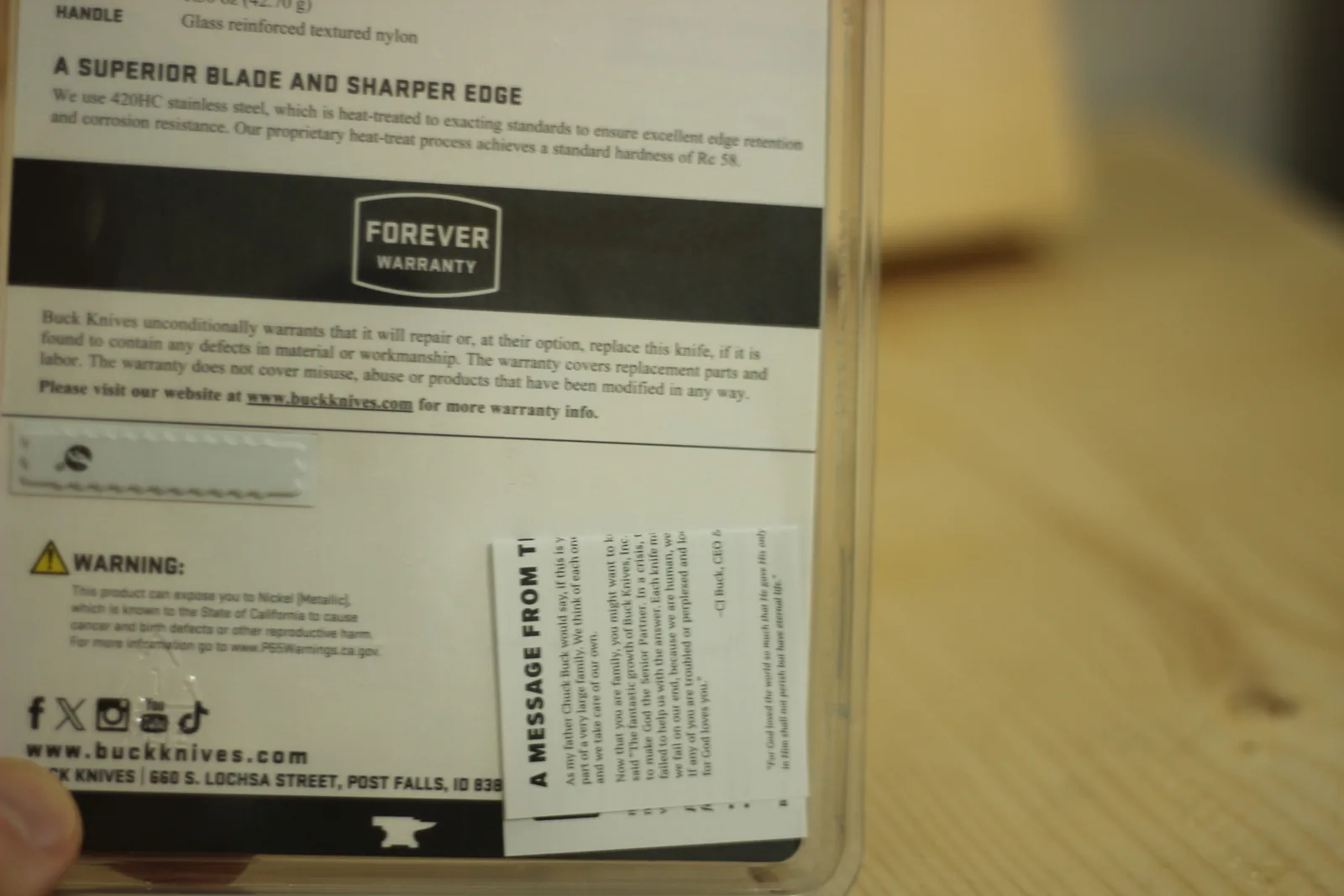 Back of the blister card with printed text about 420HC steel and a hardness of Rc 58, the Forever Warranty terms, and the Buck Knives Post Falls Idaho address