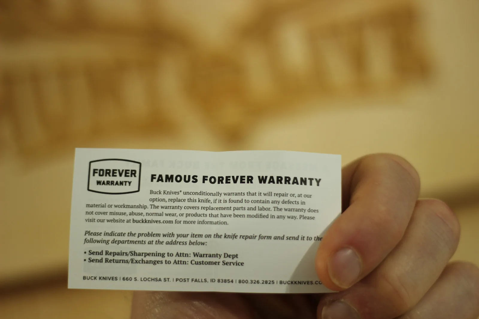 Printed card headed FAMOUS FOREVER WARRANTY explaining Buck's unconditional repair or replace policy with the Post Falls Idaho return address
