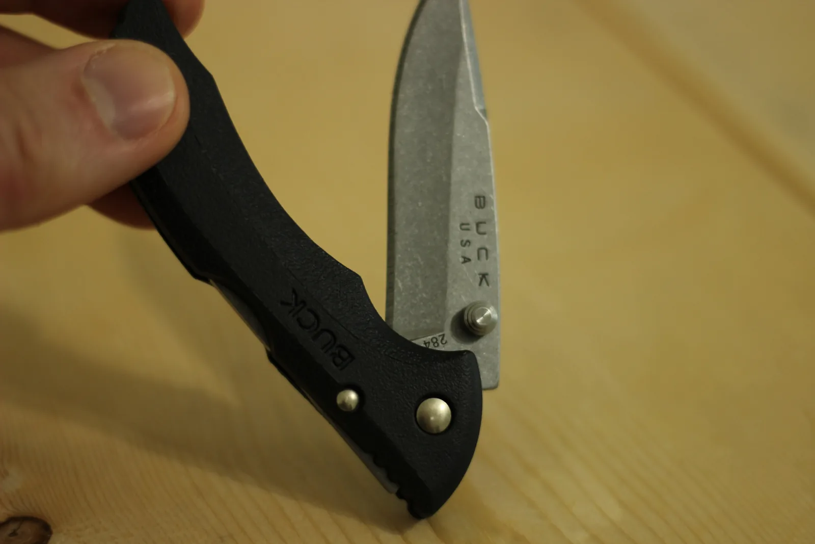 The knife half-open held vertically with the BUCK USA stamp and 284 model number readable on the blade