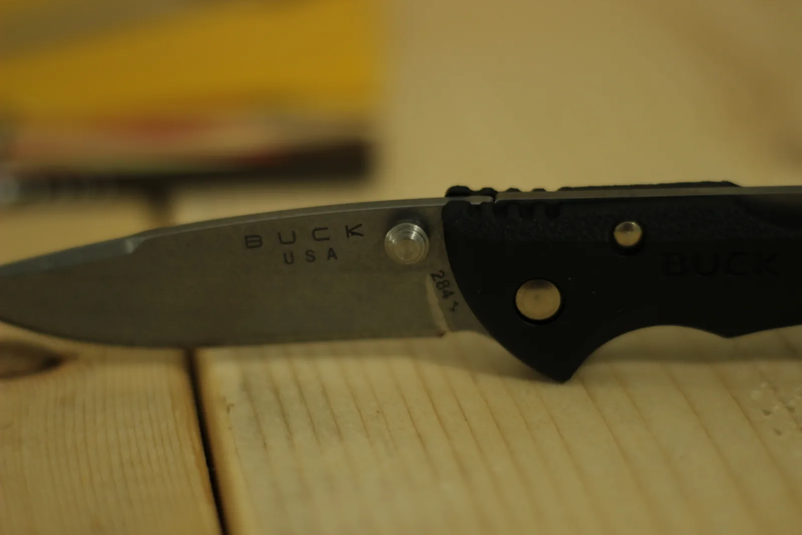Close-up of the blade tang stamped BUCK over USA with the model number 284 below, and two polished rivets in the black handle