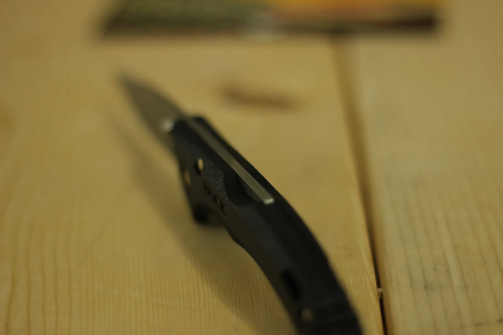 The closed knife photographed end-on down the length of the handle showing the contour and the tip protruding