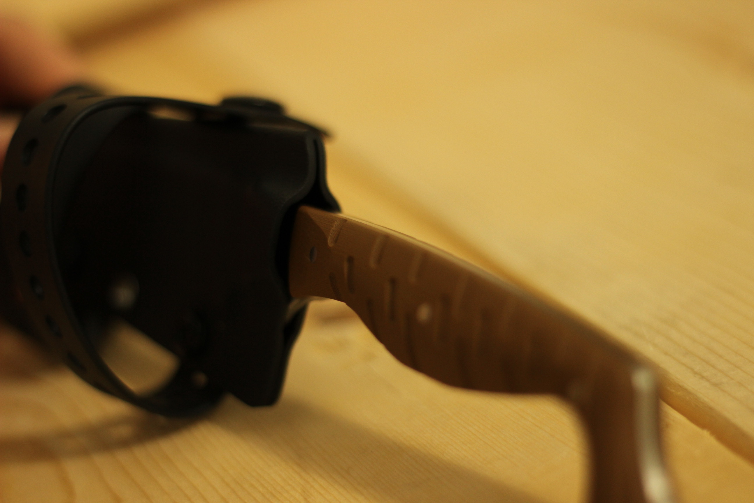 The Civivi MDRN Hunter being partially drawn from its kydex sheath at a steep angle, the brown G10 handle and the start of the blade visible emerging from the throat of the sheath