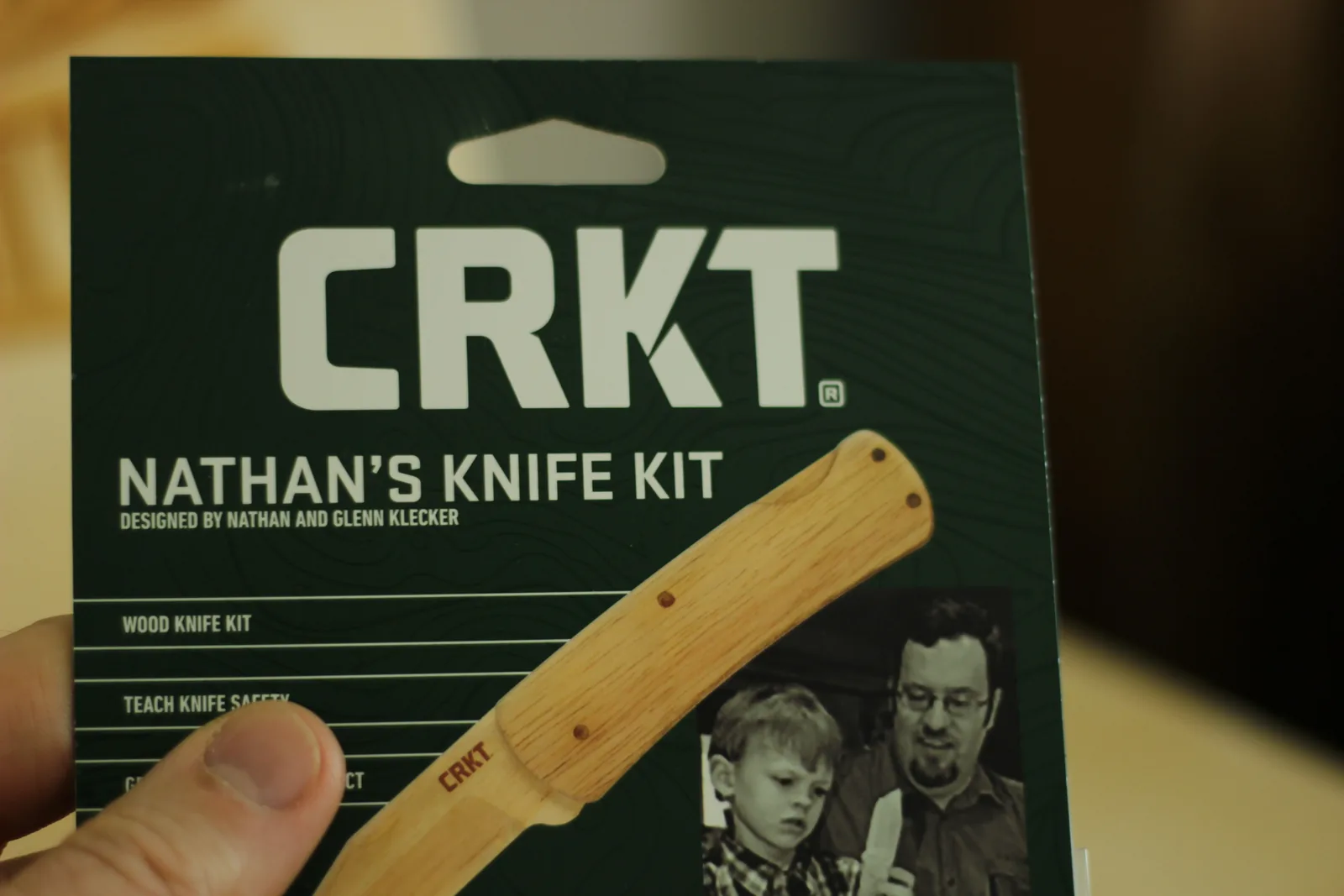 Close-up of the card front reading CRKT Nathan's Knife Kit, designed by Nathan and Glenn Klecker, with a photograph of the finished wooden knife