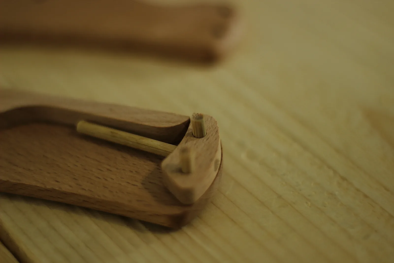 Close-up of the tail end of the lock bar with the dowel spring resting against it inside the handle scale