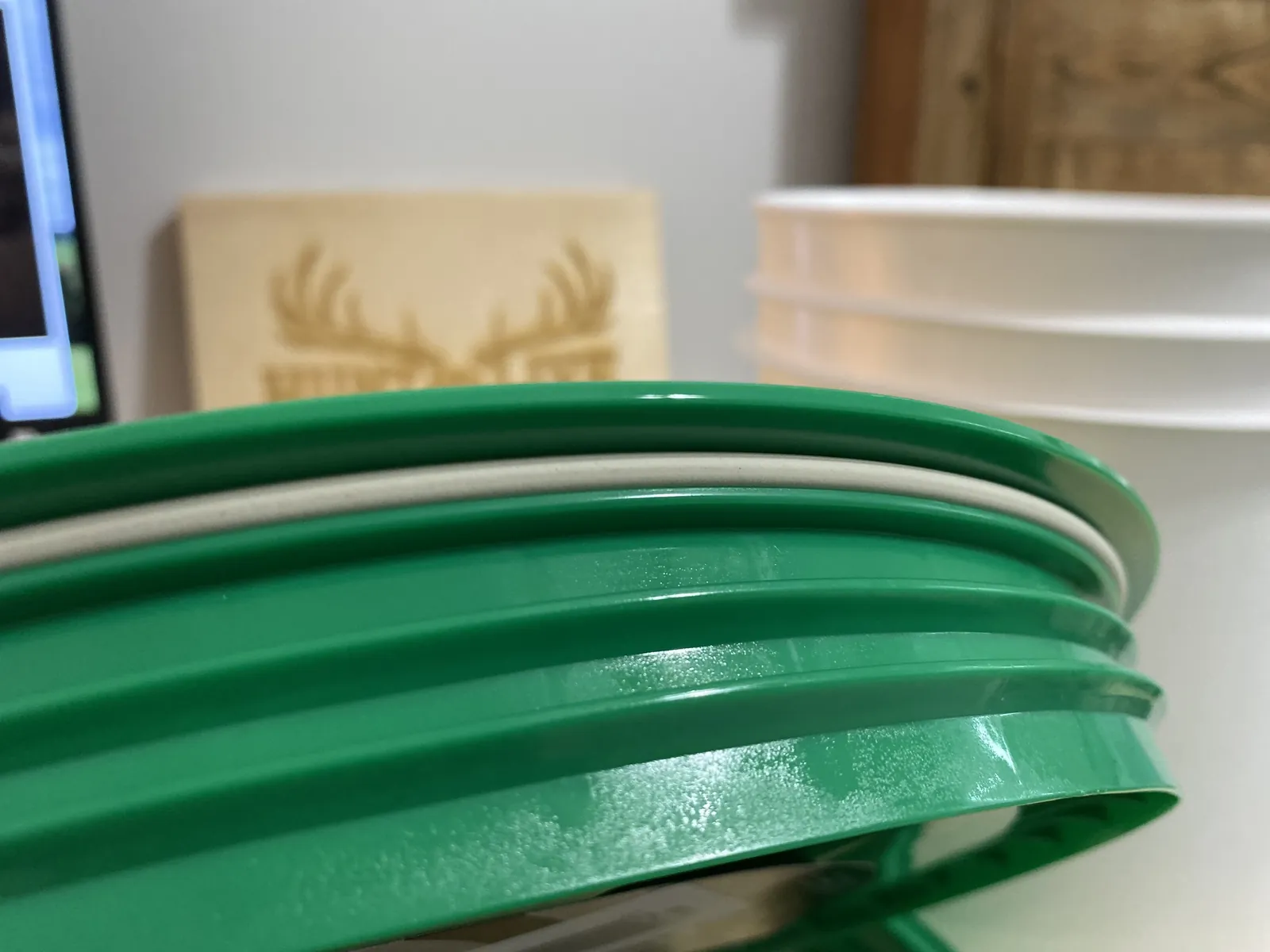 Side close-up of the GAMMA Seal Lid threads showing the multiple coarse external threads and the amber elastomeric gasket band between the threaded lid and the adapter ring