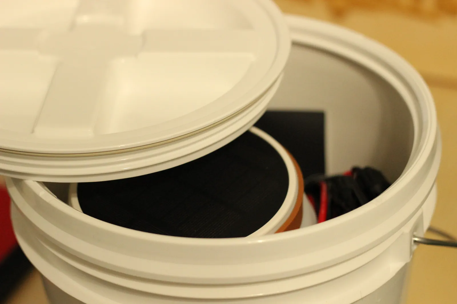 Top-down view into a white 5-gallon bucket with the GAMMA Seal Lid removed, showing a Kraft paper mylar bag inside that holds the bulk dry good