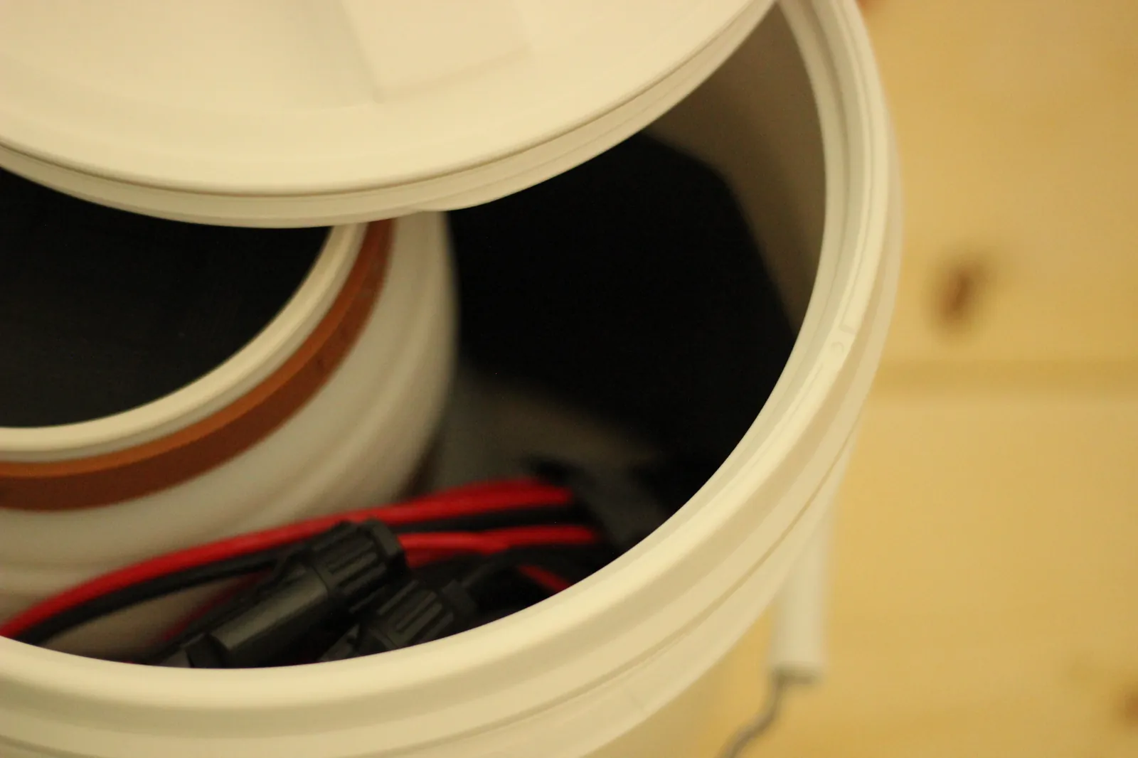Close-up of the GAMMA Seal Lid being lifted from the bucket revealing the solar panel and connectors inside