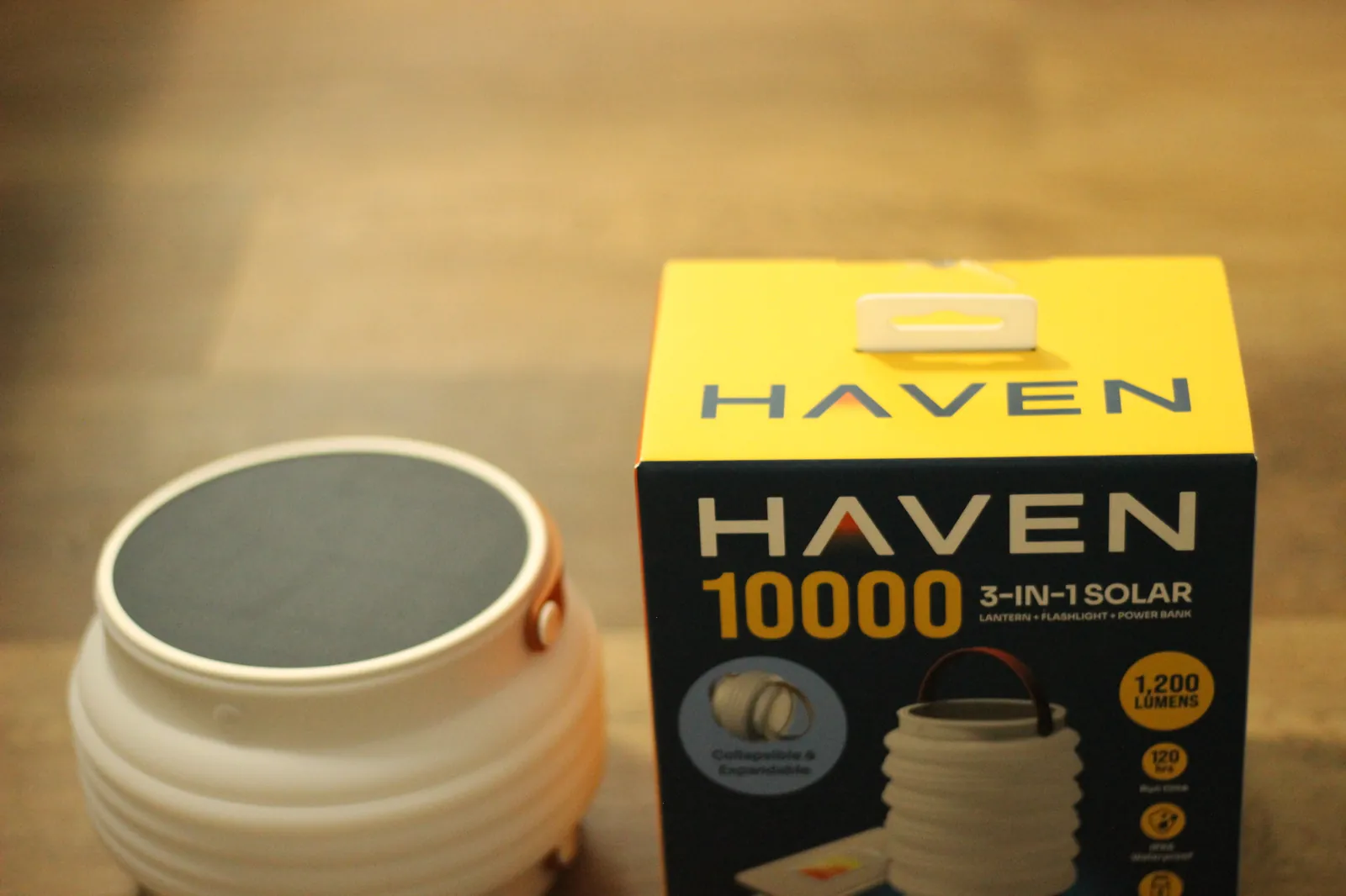 HAVEN 10000 retail box beside the collapsed lantern showing the matte-white silicone body and dark solar panel top