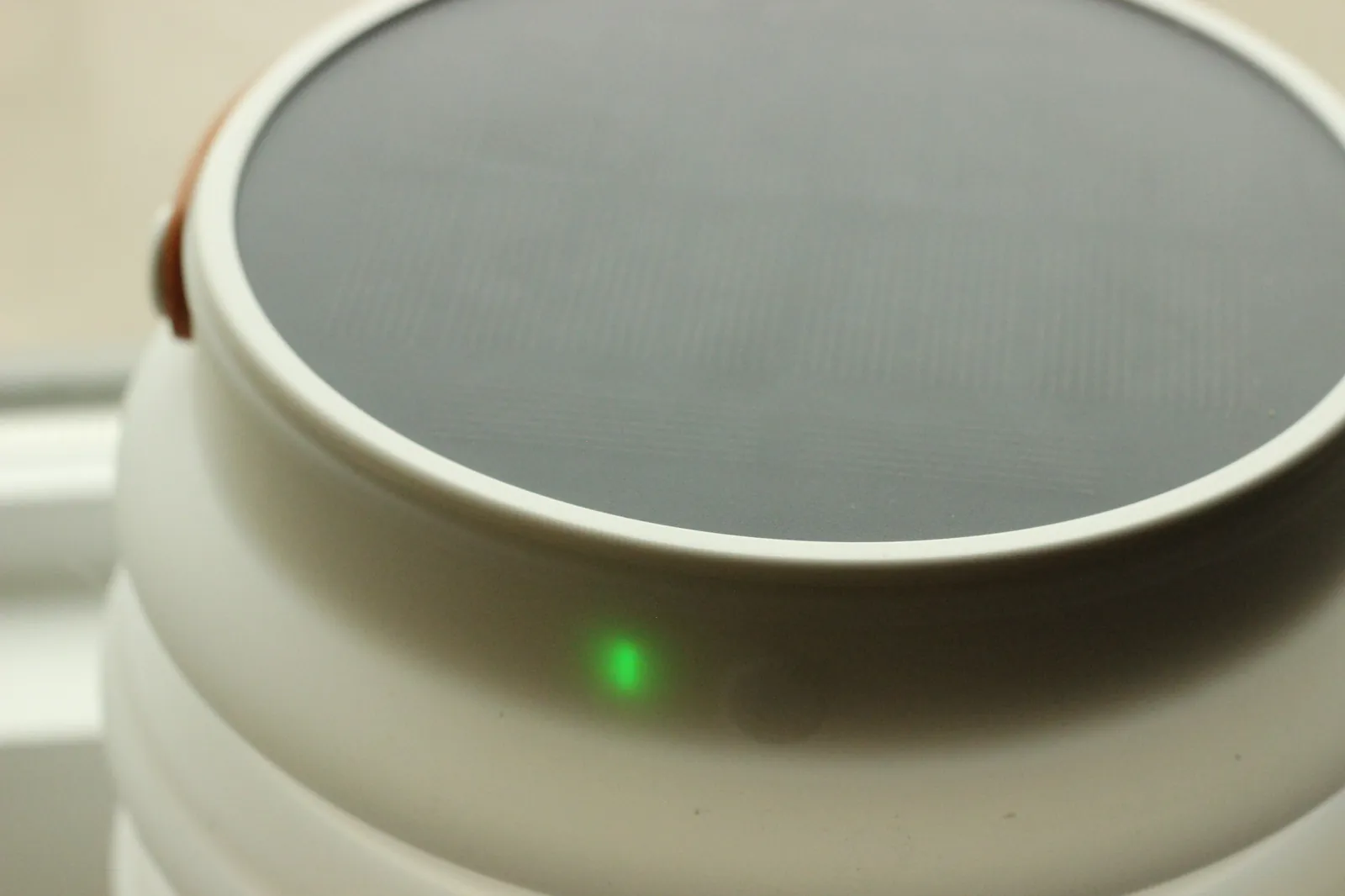 Solar panel close-up with green charge LED visible just under the rim