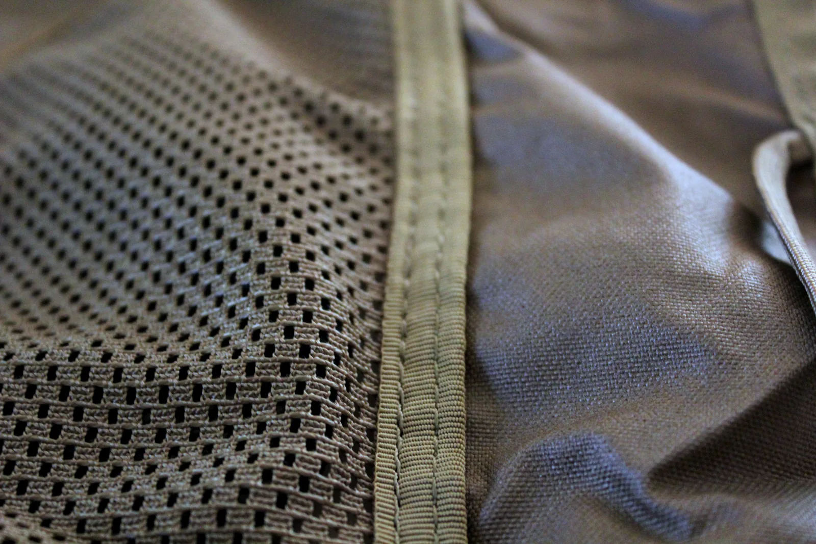 Close-up of the open polyester mesh panel let into the side of the seat, bound with webbing tape
