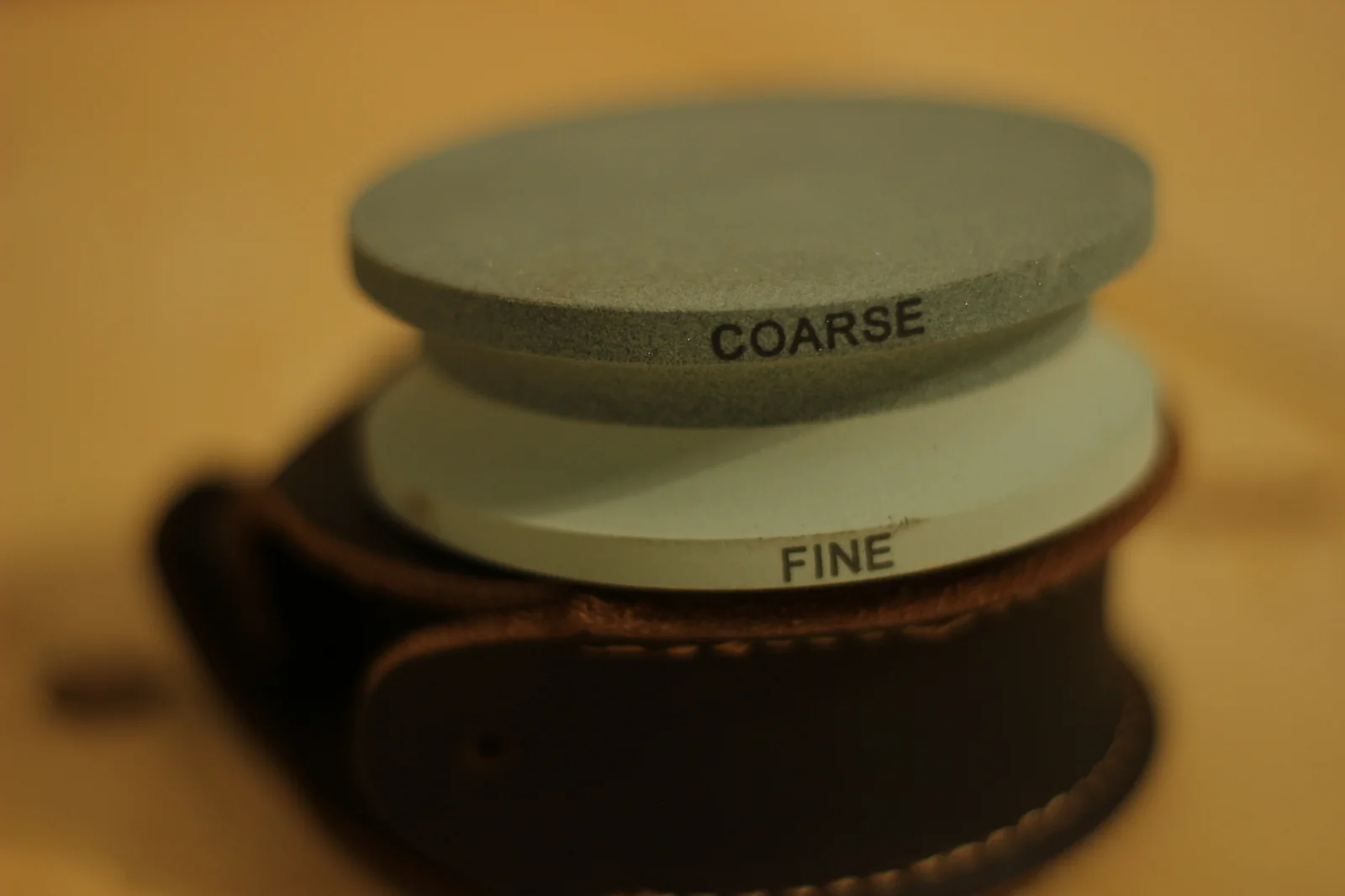 Grinding stone with the words COARSE and FINE printed on the side edge of each respective face