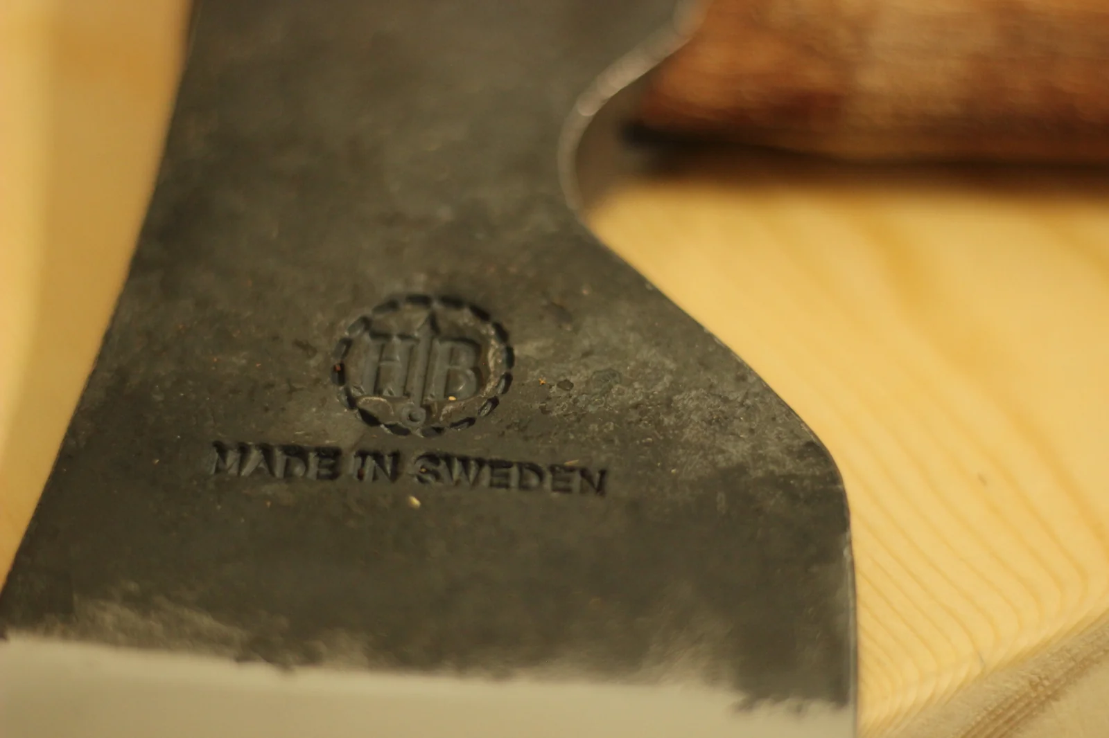 Detail of the MADE IN SWEDEN stamp visible just above the polished and lightened cutting edge of the axe head