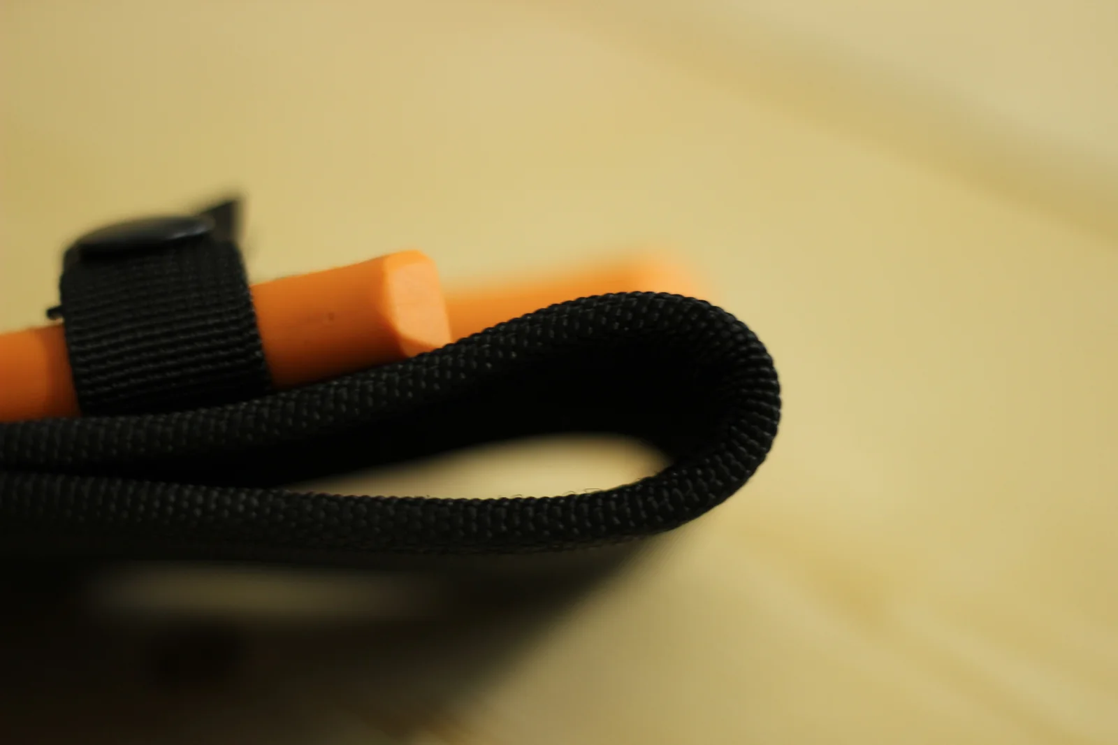 Close-up of the sheath belt loop showing the wide nylon webbing belt slot at the back of the sheath