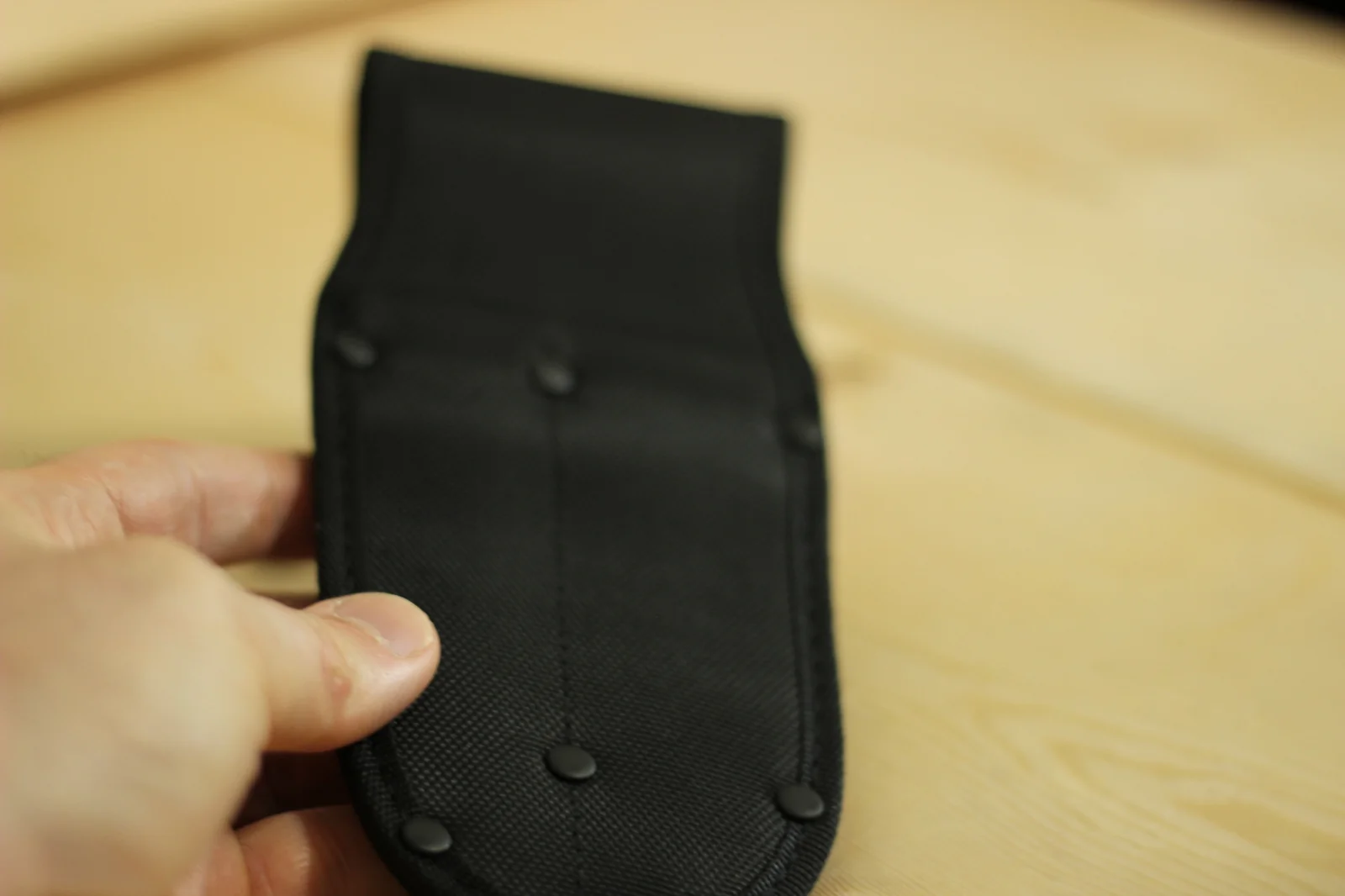 The back of the empty double sheath held in hand showing the dual blade pockets stitched into the body of the sheath