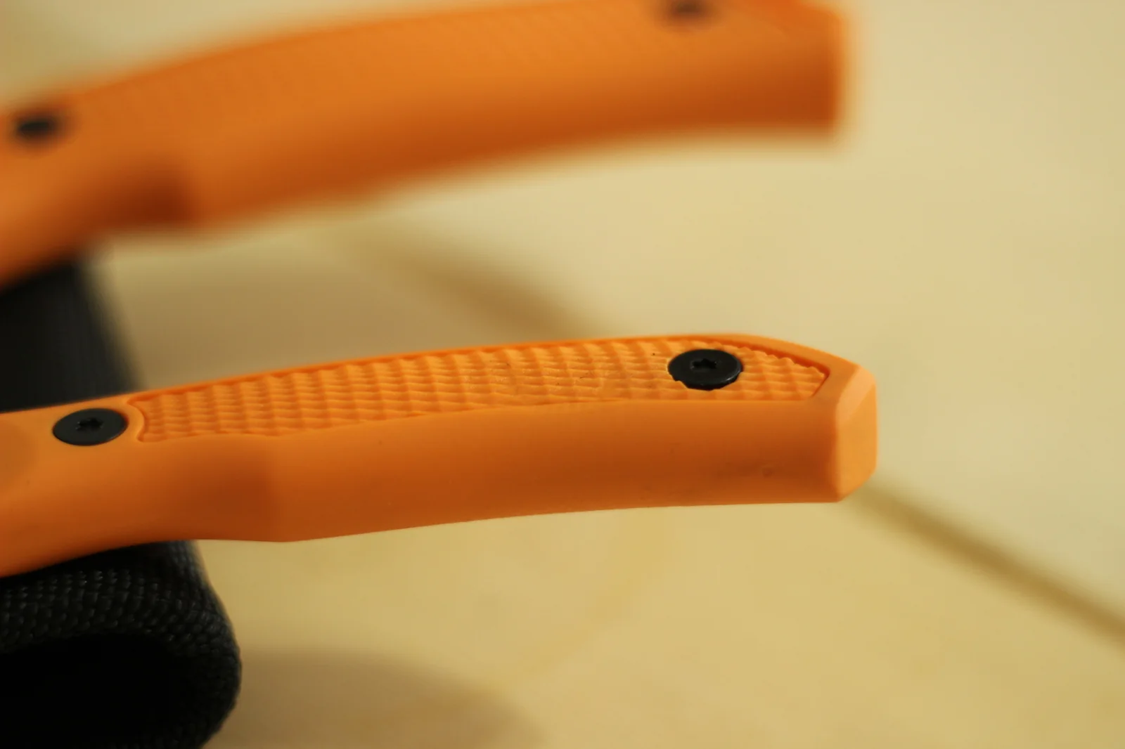 Macro of the handle butts of both knives side by side showing the contoured shape and torx screws