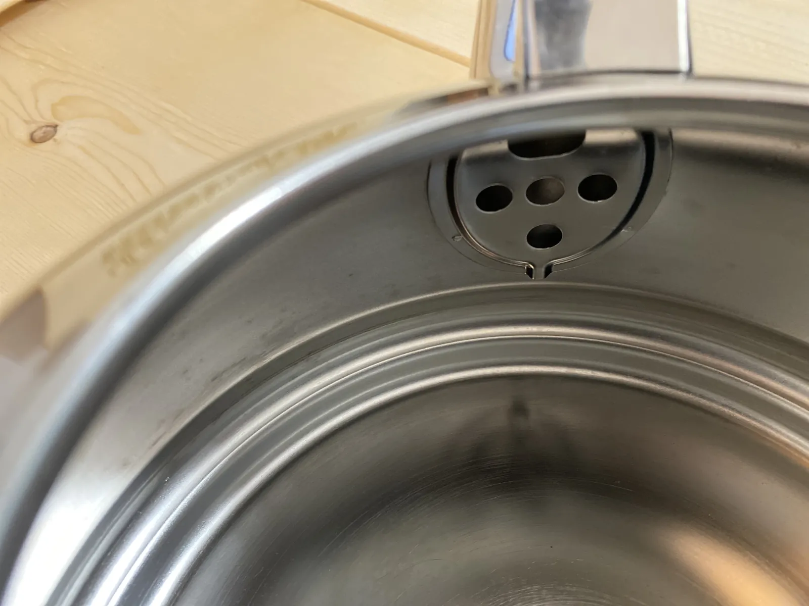 Inside the kettle — bare stainless interior with the spout's stainless mesh strainer visible