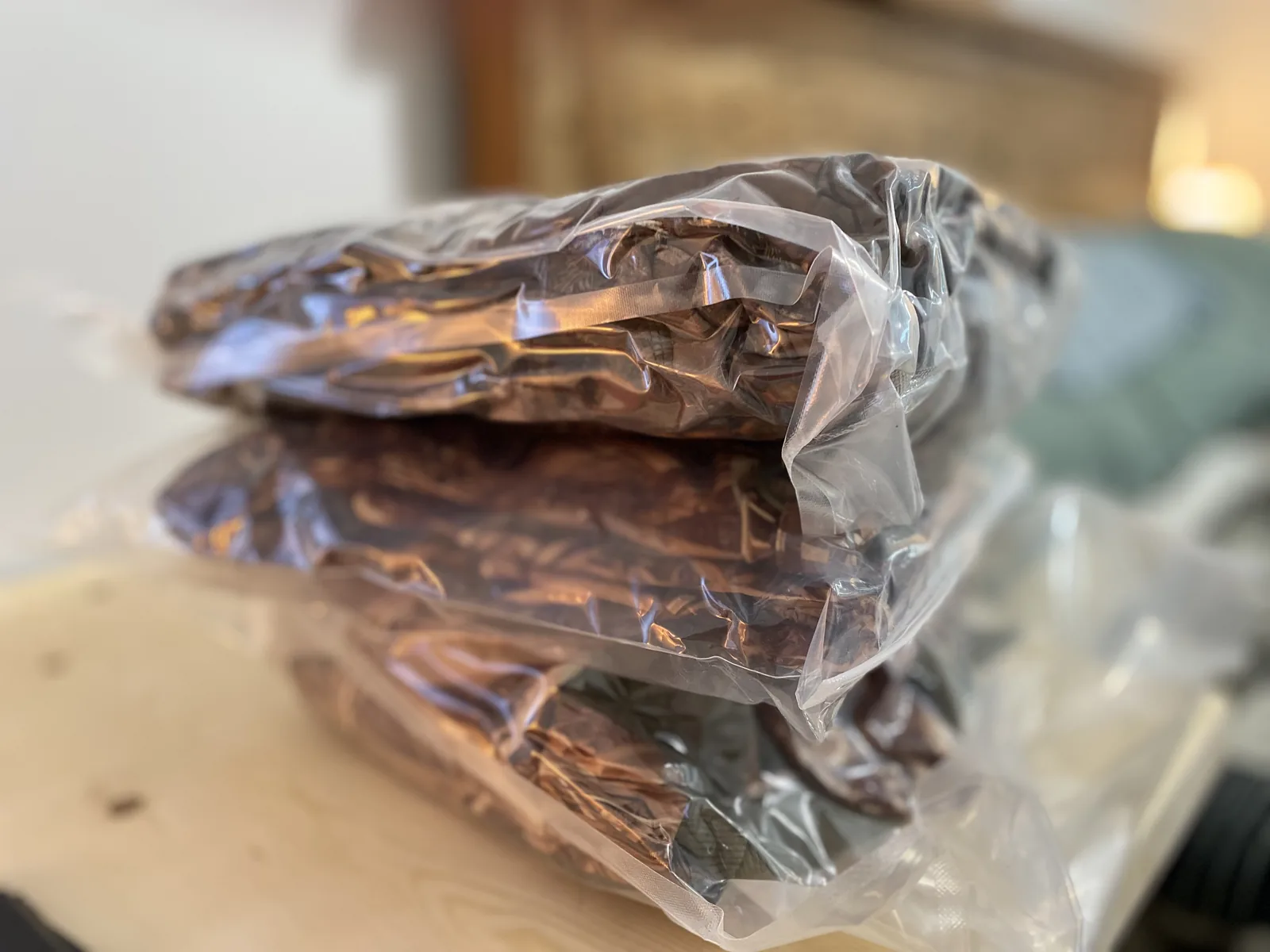 The bagged camo jacket and pants stacked together on a wooden surface