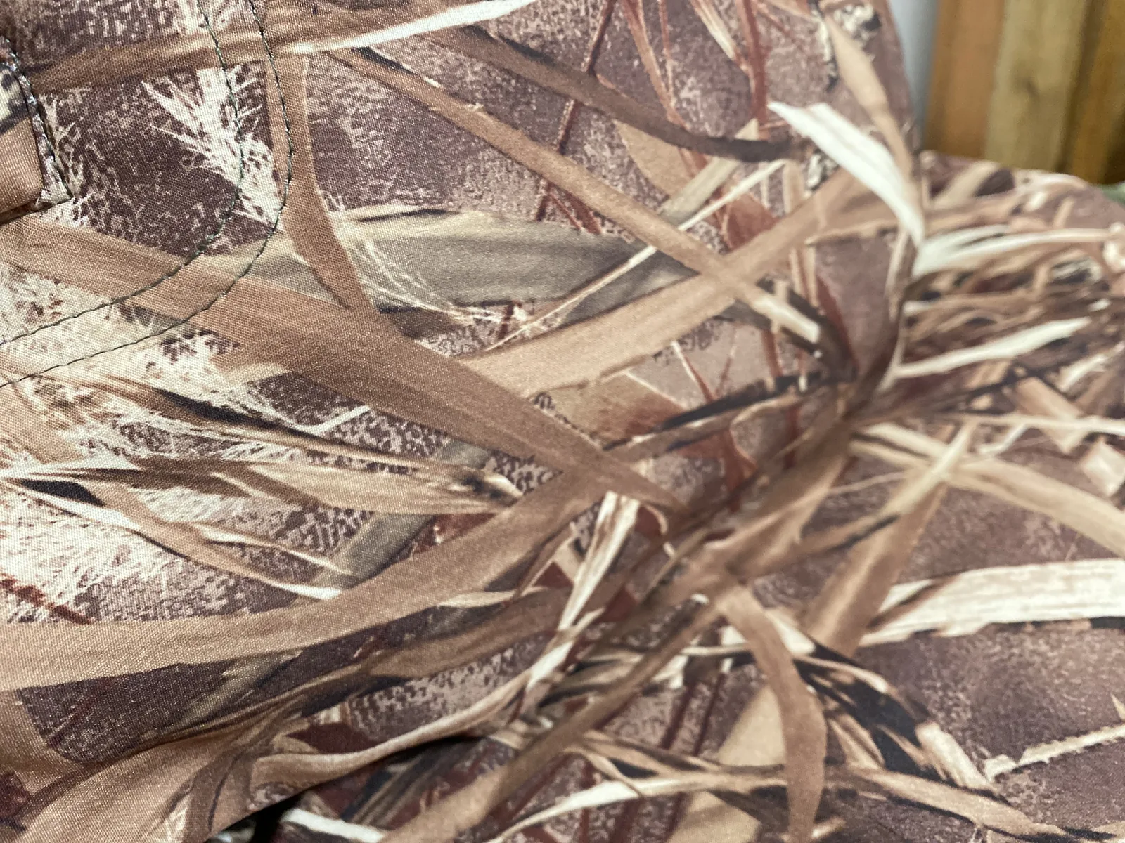 Close-up of the NV Reeds camo print showing pale broken stalks over a dark brown ground