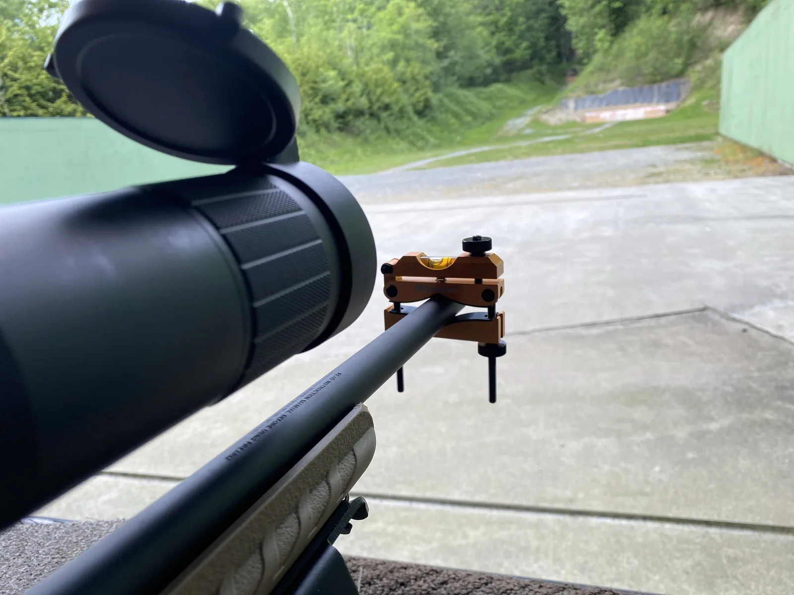 Ruger American Ranch on the bench with scope caps open, bipod deployed, range downrange