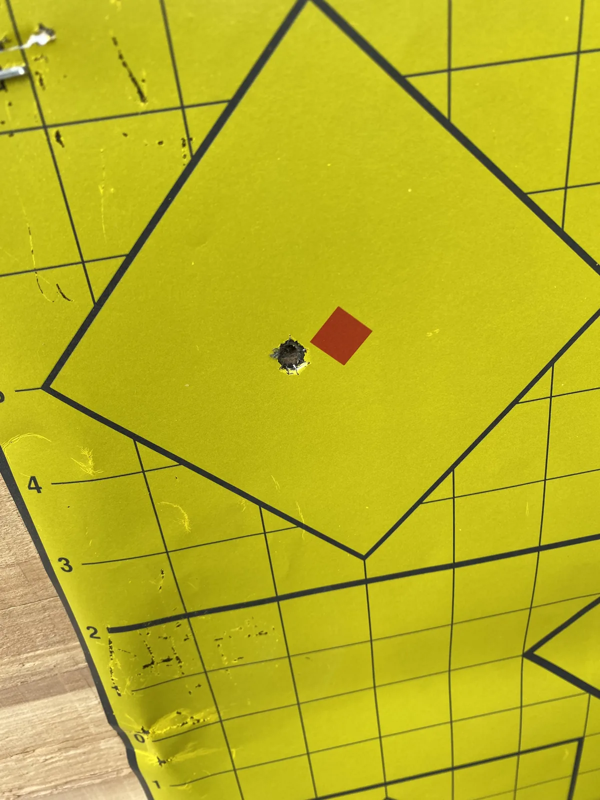 Ruger American Ranch in FDE stock on a shooting bench with magazines, cleaning kit, and ammo can laid out, range downrange