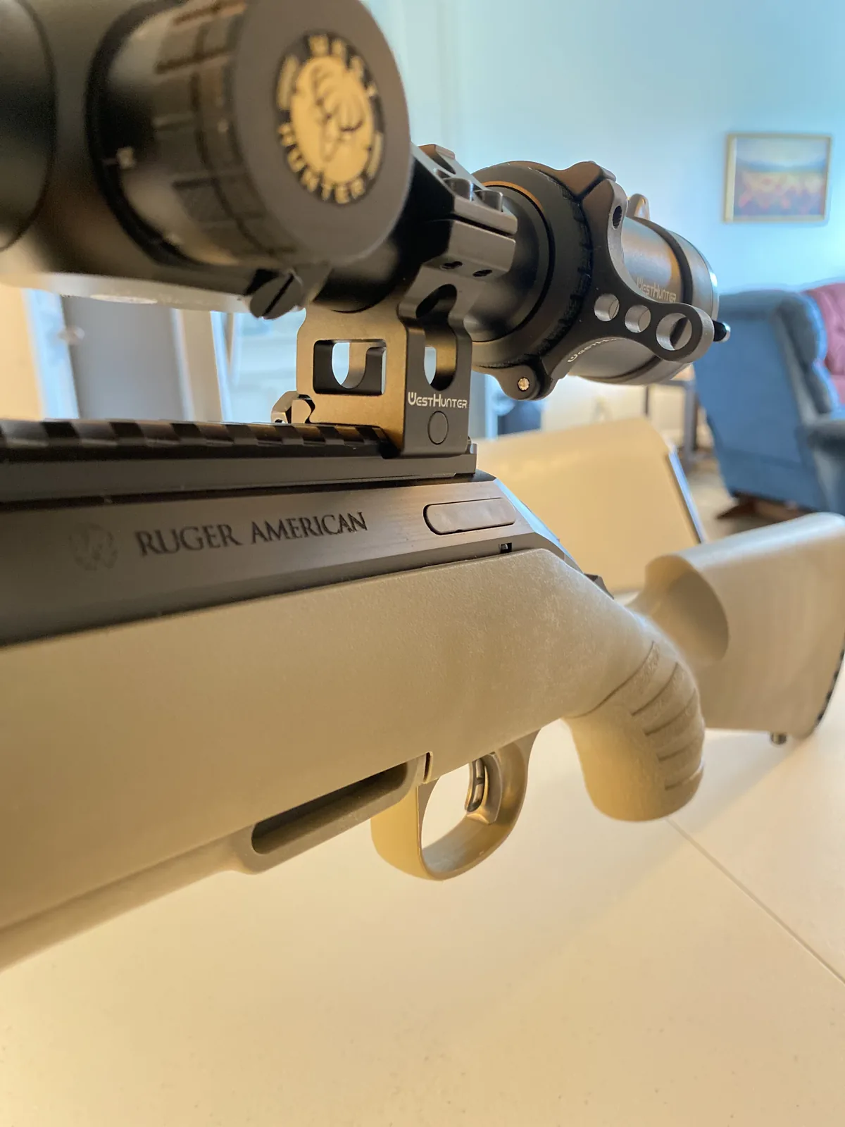 Bolt handle and receiver of the Ruger American Ranch with West Hunter scope and rings mounted above the integral rail