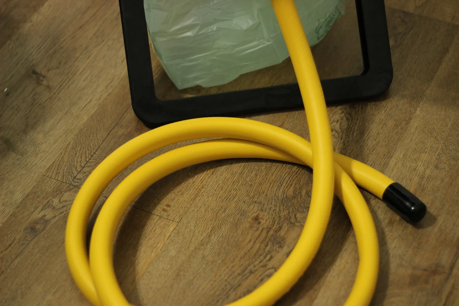 Yellow vinyl urine diversion hose coiled before installation