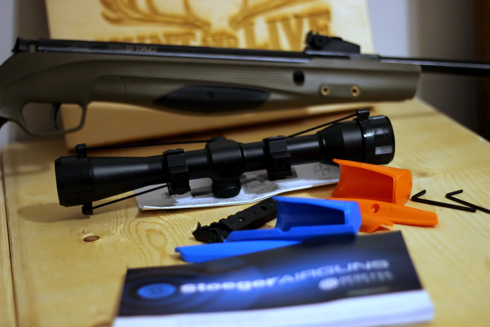 The 4x32 scope beside the manual and the orange and blue polymer inserts