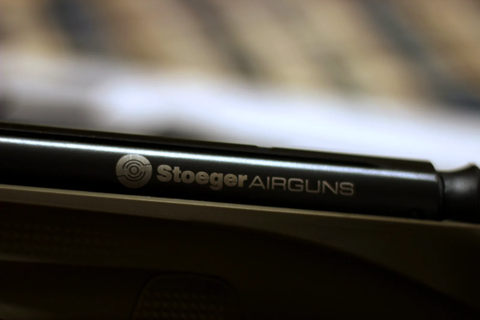 The Stoeger Airguns logo printed on the compression tube of the rifle